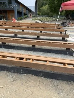 This stage focuses on the supporting structure beneath the benches. Wood framing and blocking are installed along the seating rows before the top boards are added.