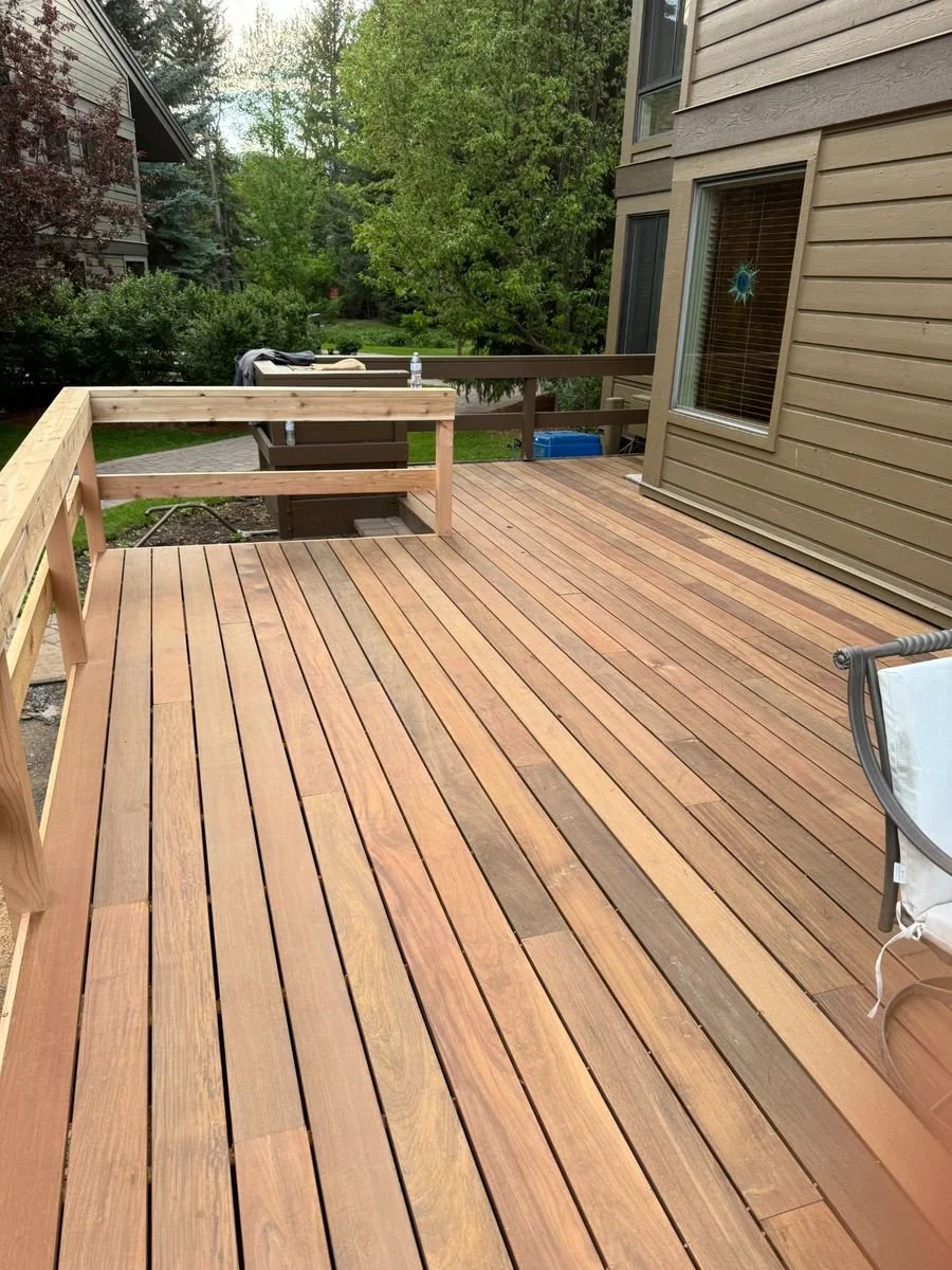 Another view of the deck project highlights the board installation and railing work around the seating area. The layout maintains access between the home, deck and existing garden walkway.