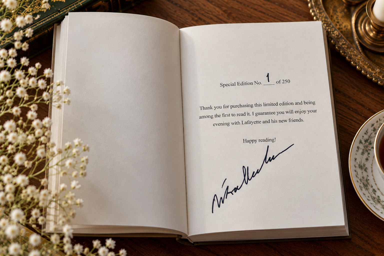 Open book with a special edition number 1 of 250, signed by Lafayette, on a wooden table with white flowers, a gold-trimmed cup of coffee, and a decorative tray.
