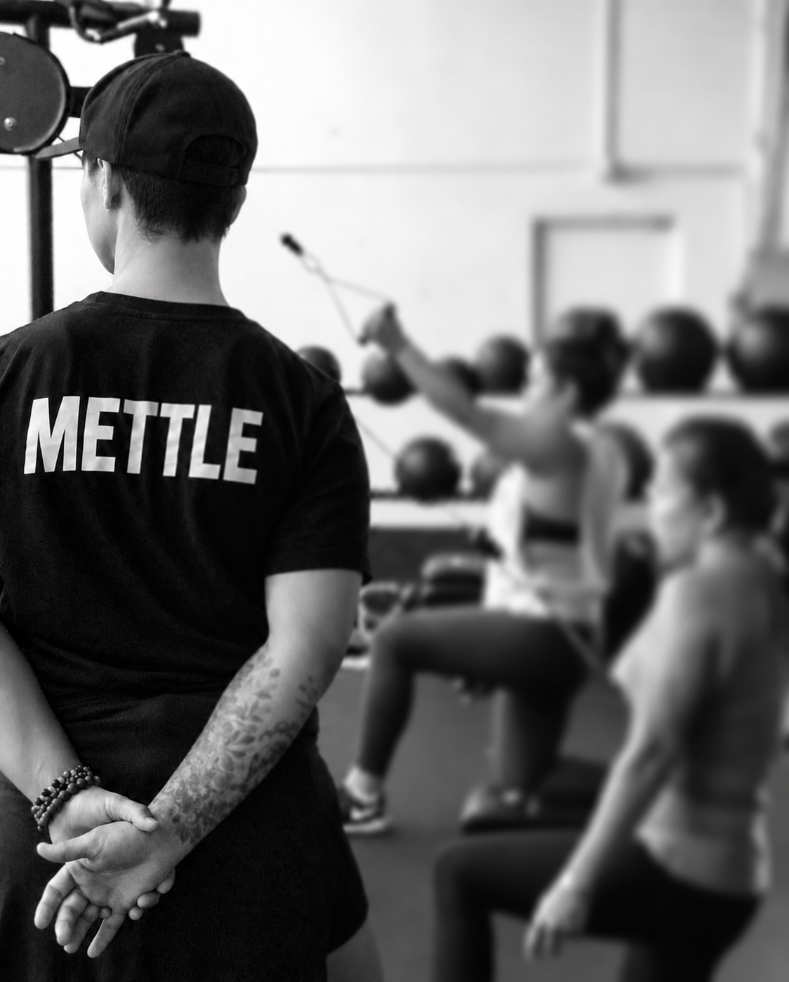 Coach Jacqui wearing a METTLE shirt while supporting a strength training class.