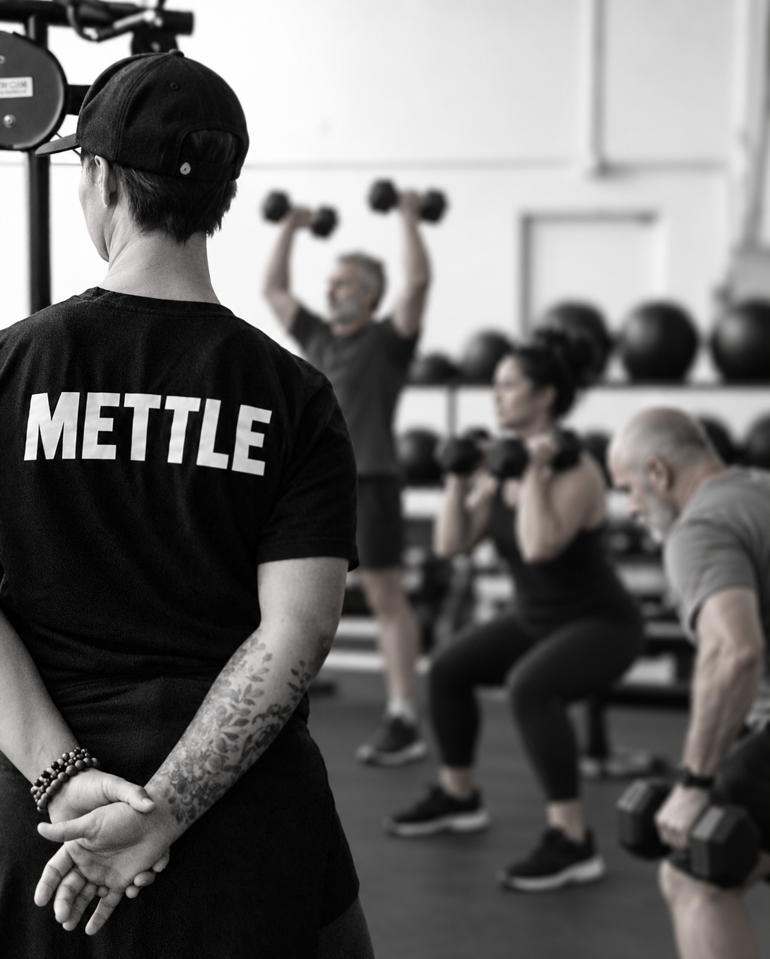 Illustrative image of Coach Jacqui in a METTLE shirt leading a group strength session with AI-generated participants.