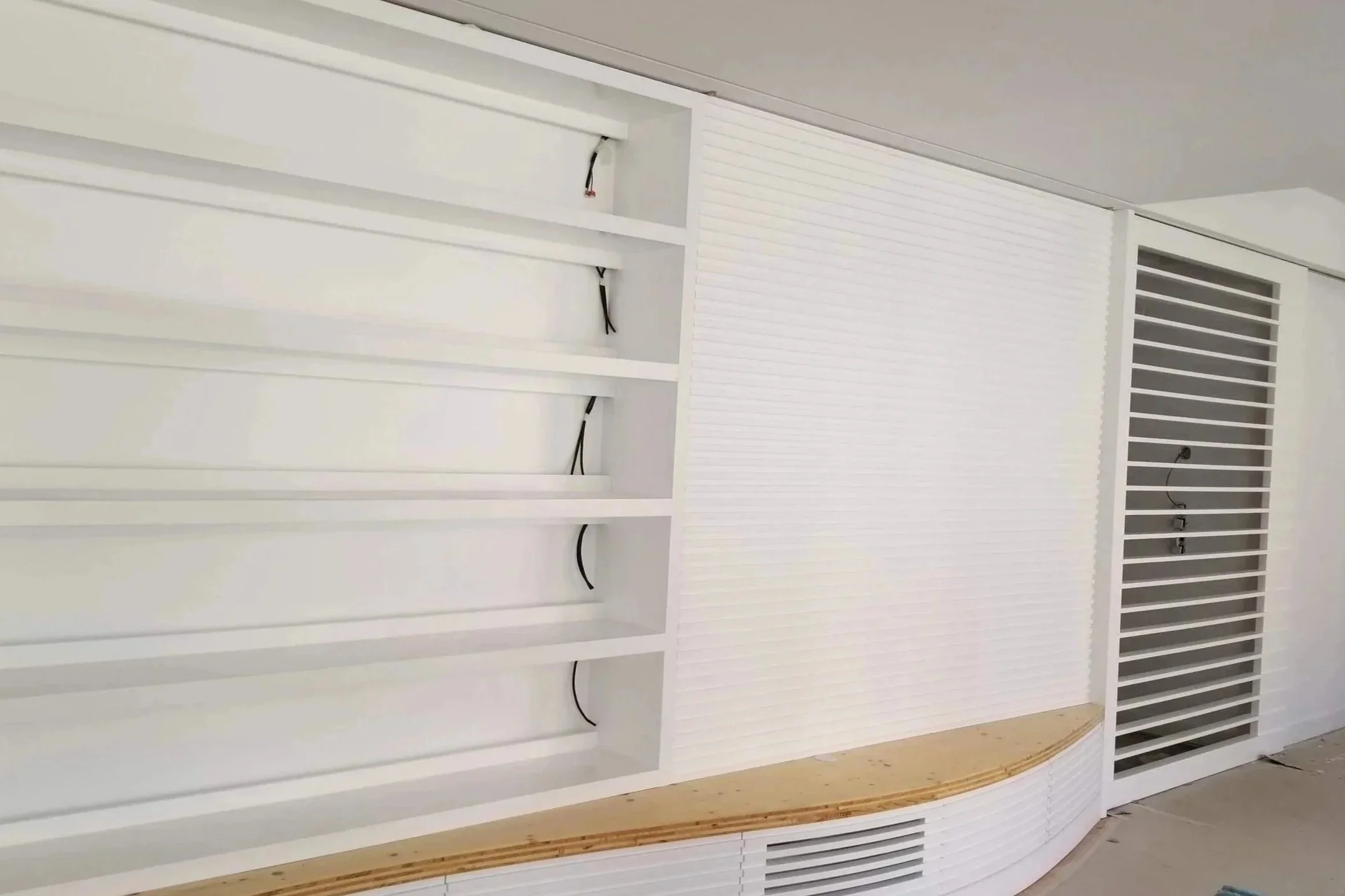 Estrutura branca para móveis, com prateleiras e compartimentos, incluindo espaço para eletrônicos e cabos, possivelmente uma estante ou gabinete em construção.