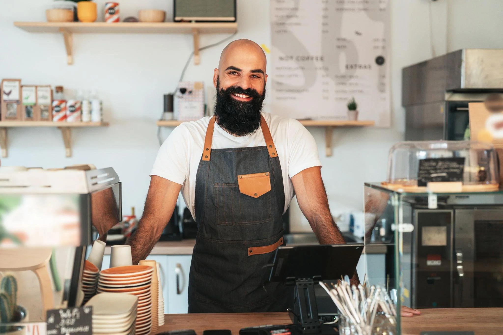 Independent restaurant owner standing behind the counter of his neighborhood café