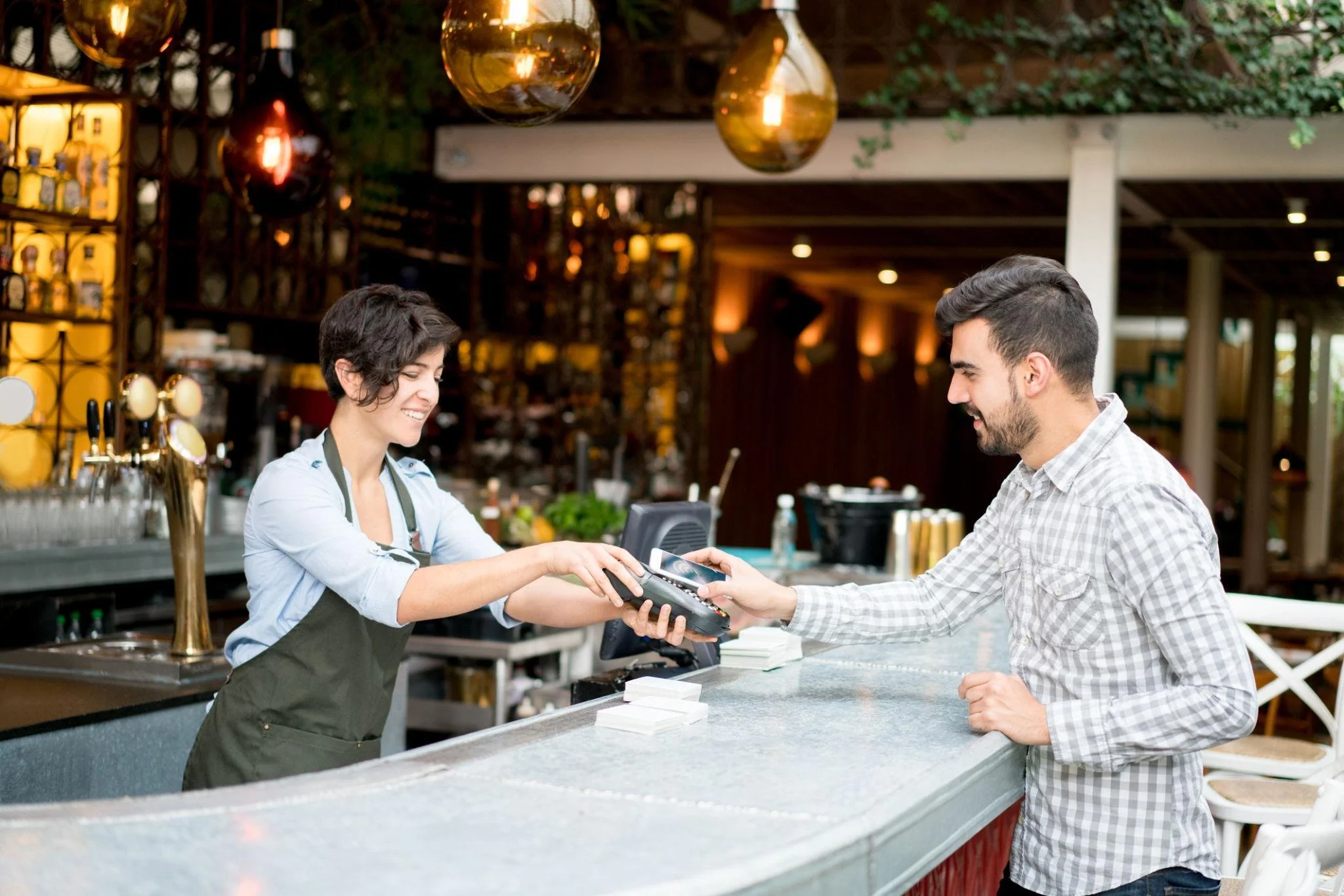 Restaurant customer completing a payment with an employee at the counter