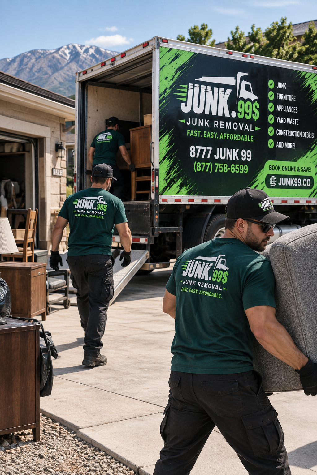 Men in green uniforms unloading furniture from a junk removal truck, with mountains in the background.