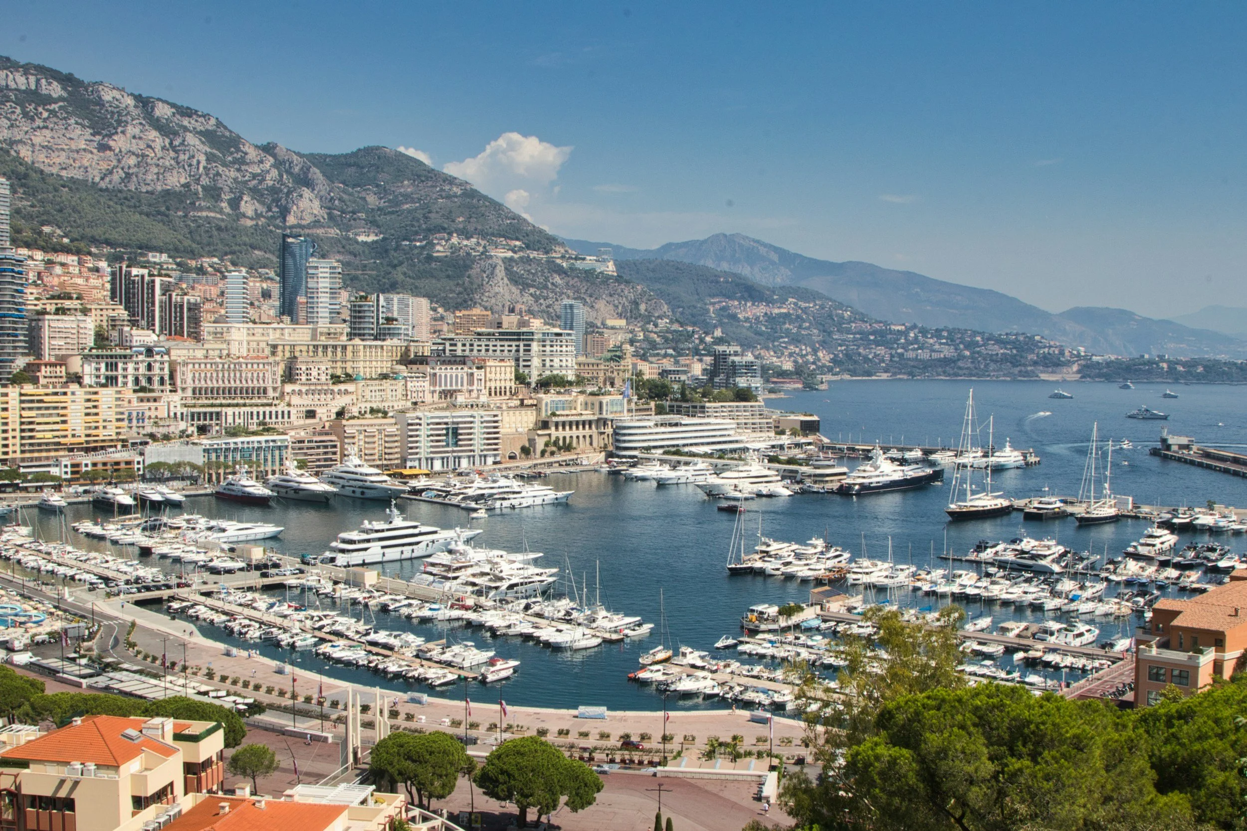 Mediterranean harbour with yachts, coastal buildings and mountains