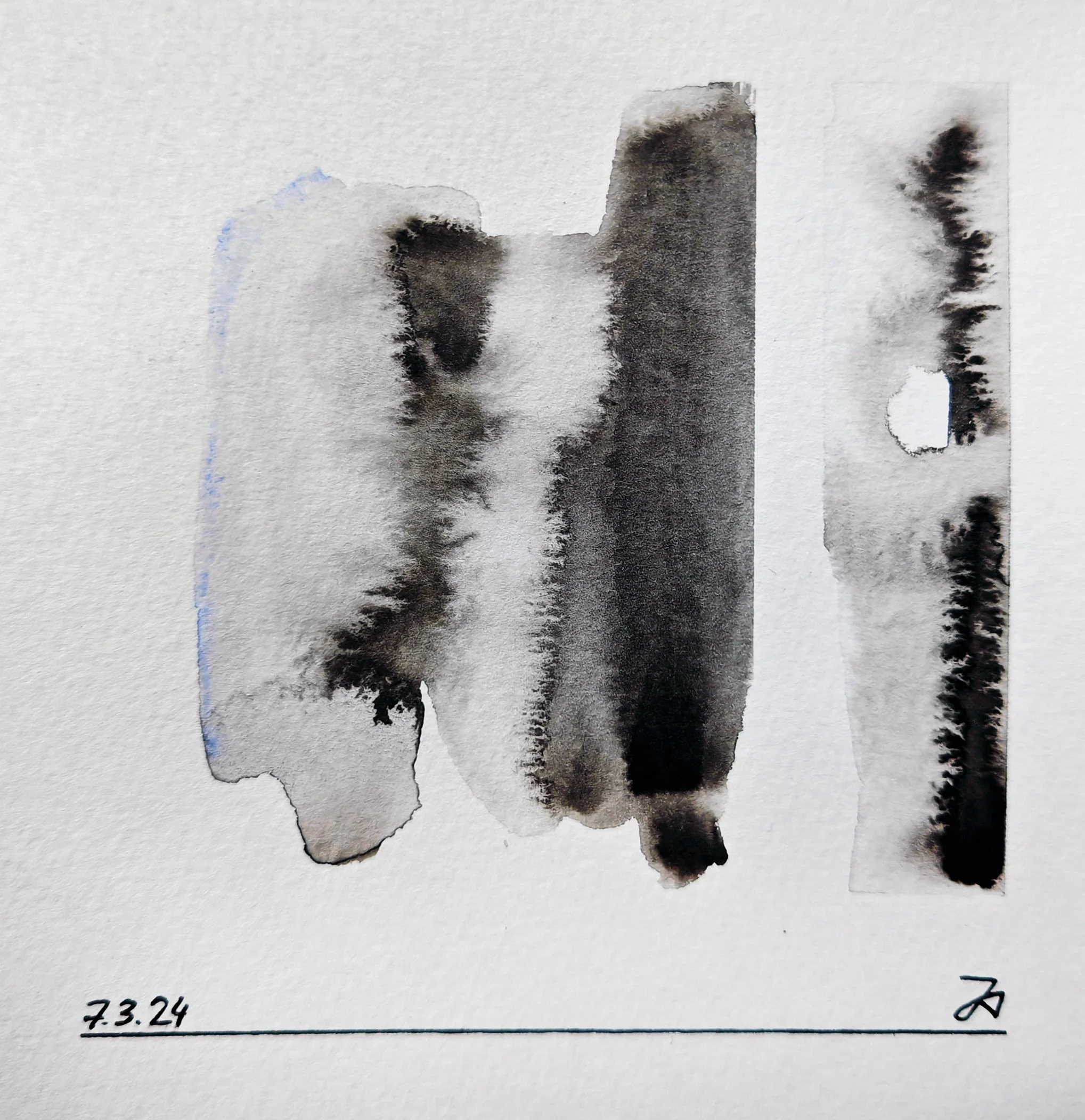 A black inkblot pattern on paper with handwritten date 7.3.24 and some additional markings.