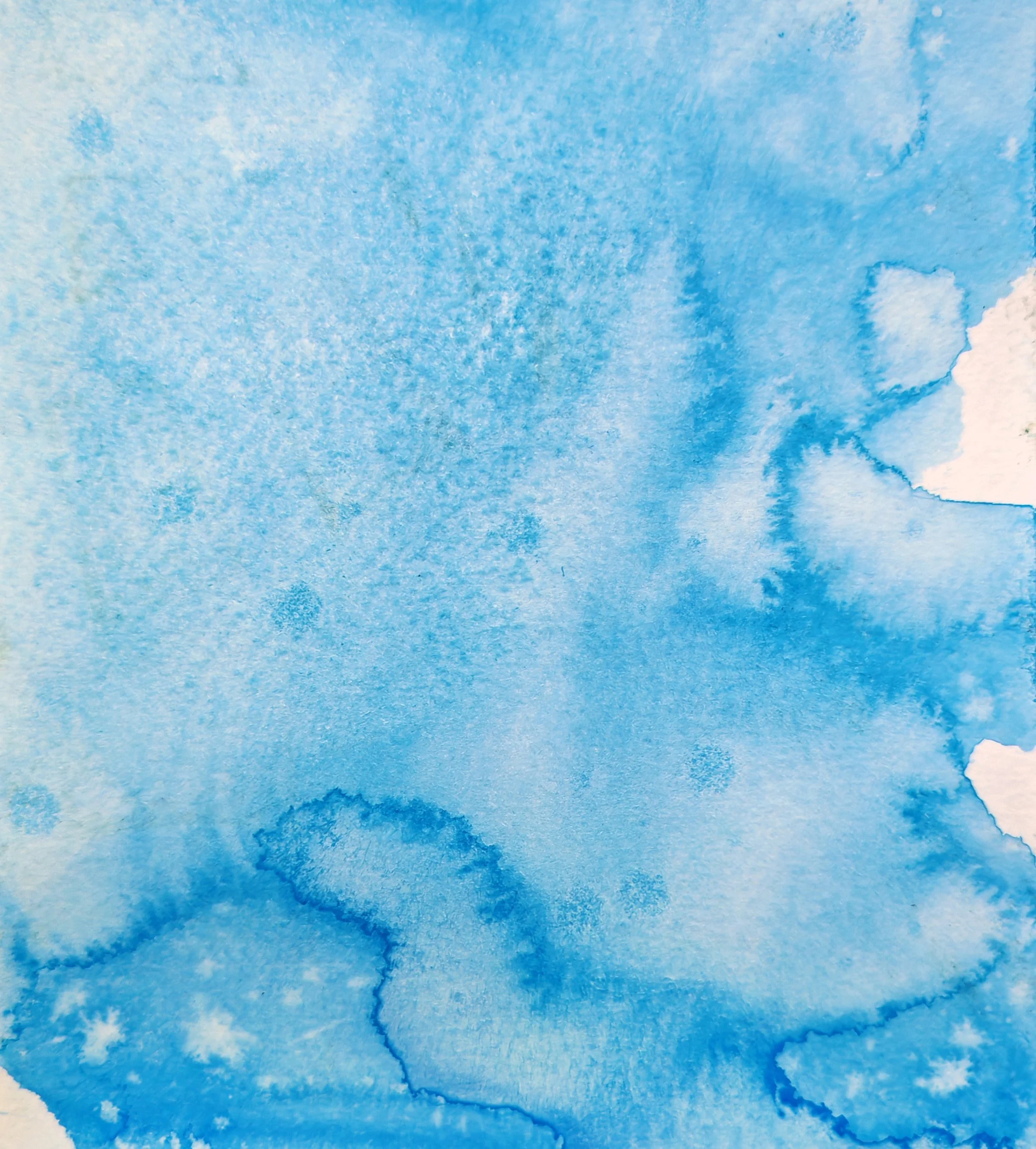 Close-up of blue watercolor paper with various shades and textures.