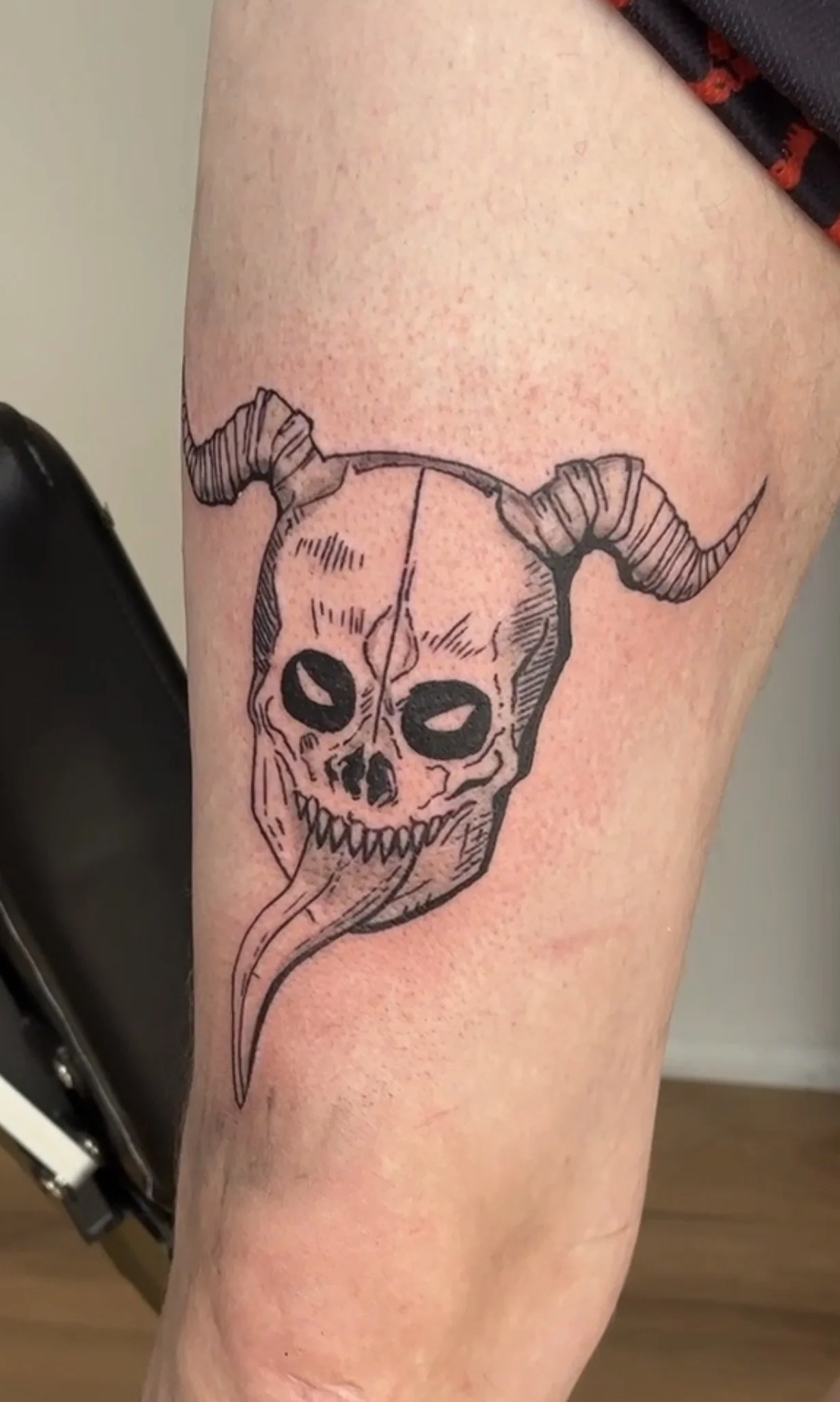 Tattoo eines Skeletts mit Hörnern auf dem Oberschenkel