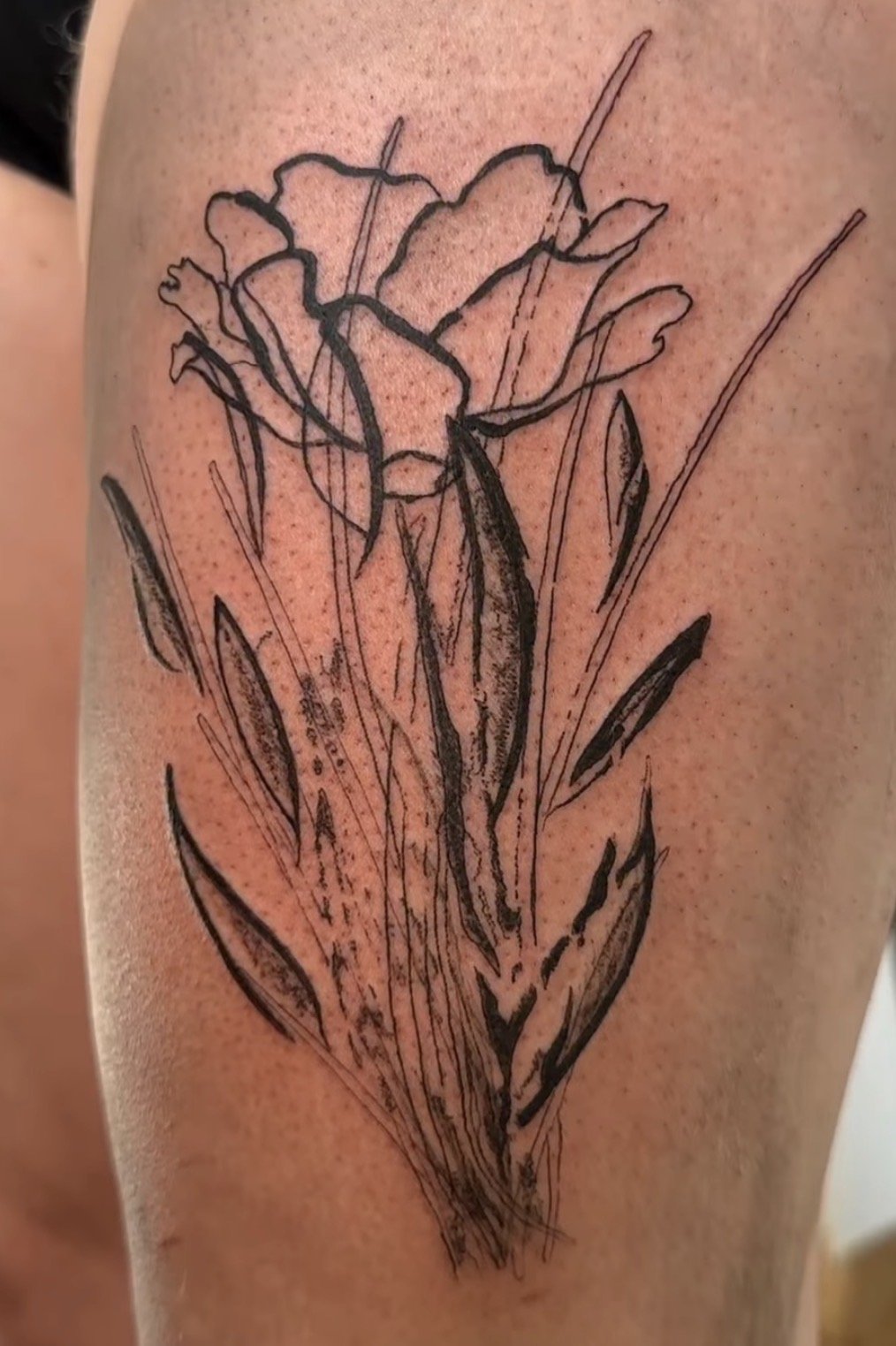Skizze einer Blume auf Haut, stilisiert mit schwarzen Linien.