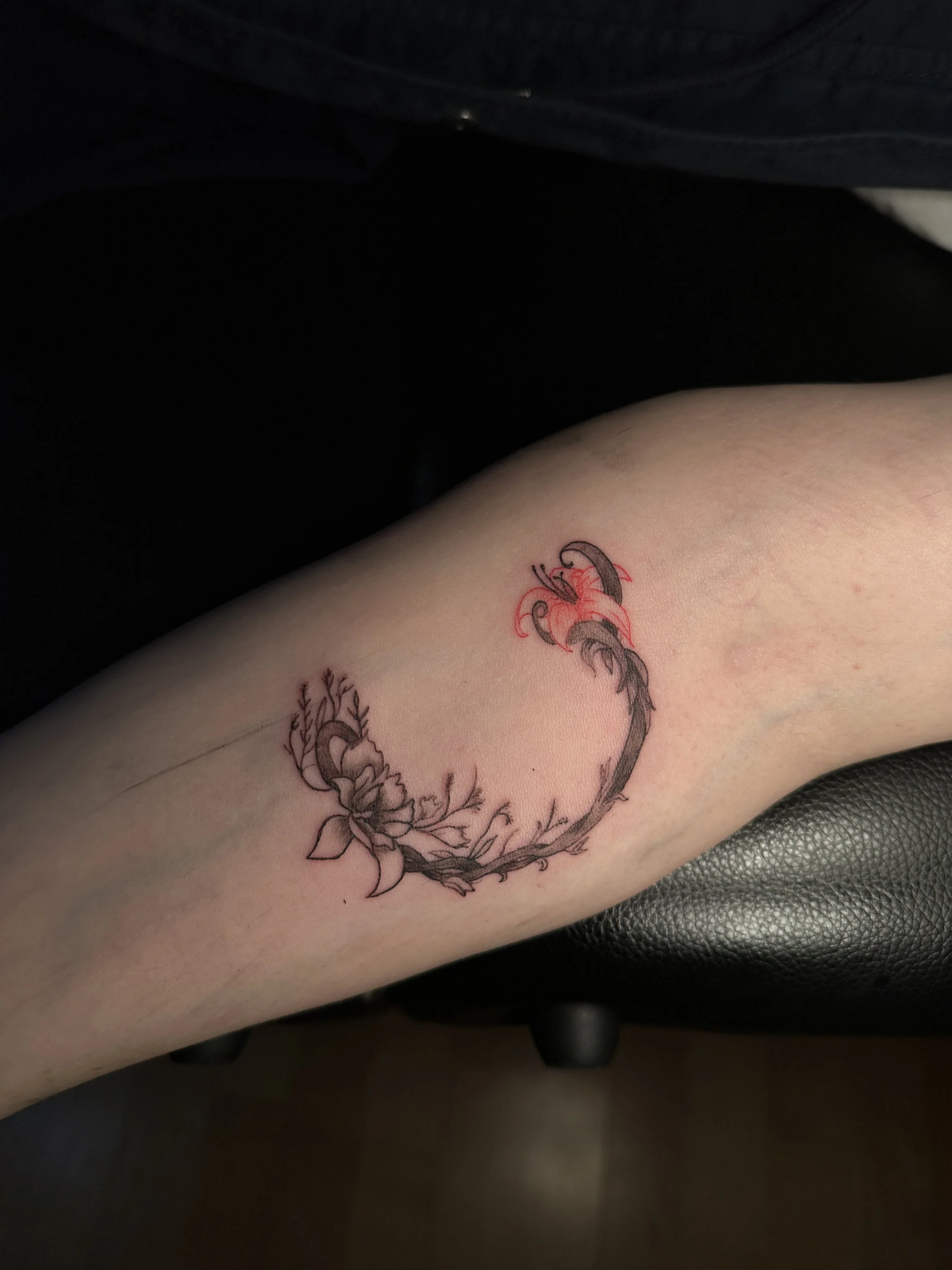 Tattoo eines Drachen mit Flammen auf dem Unterarm.