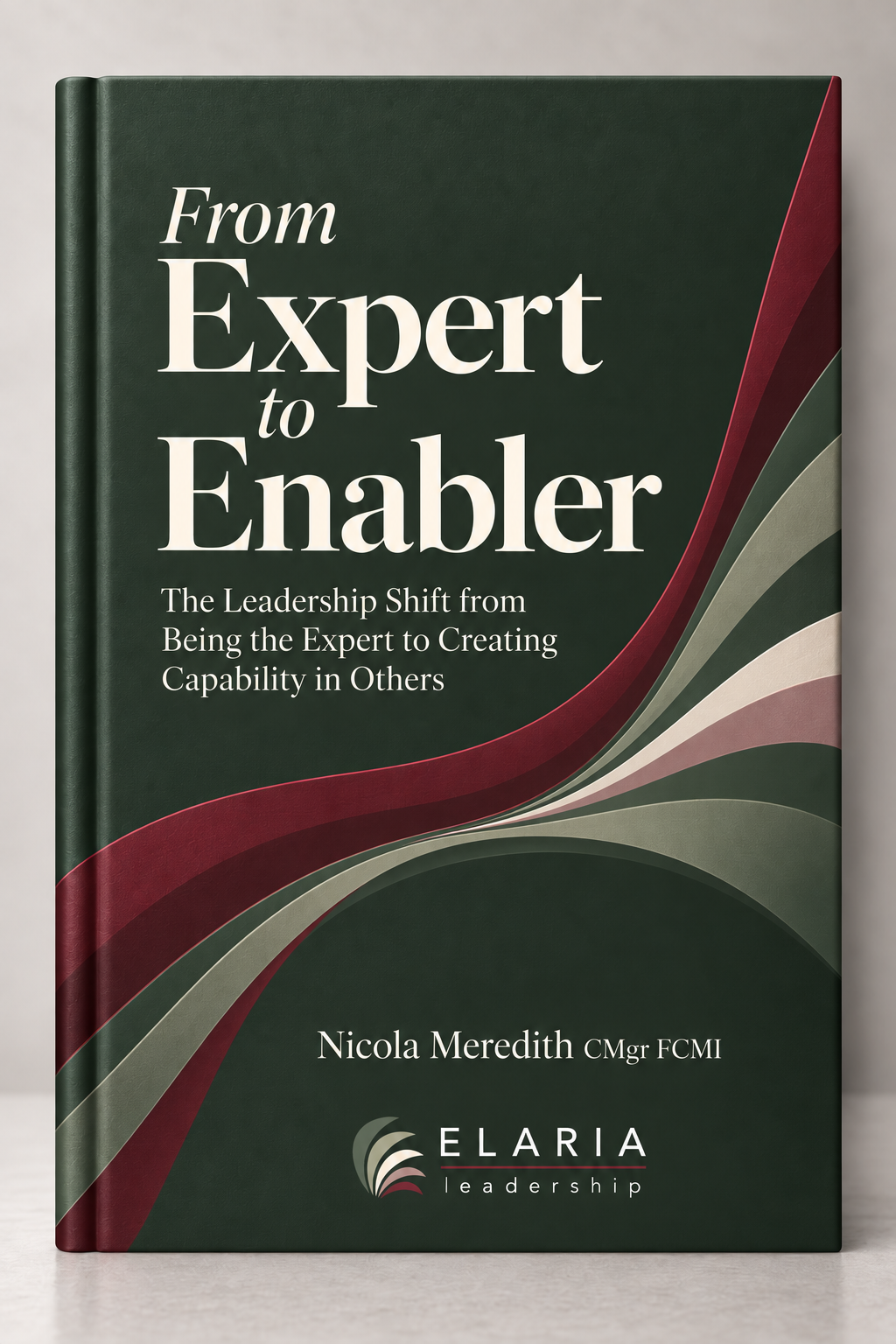 A hardcover book titled 'From Expert to Enabler' with authorship by Nicola Meredith CMgr FCMI, featuring a dark green cover with abstract wavy shapes in red, gray, and white, and the ELARIA Leadership logo at the bottom.