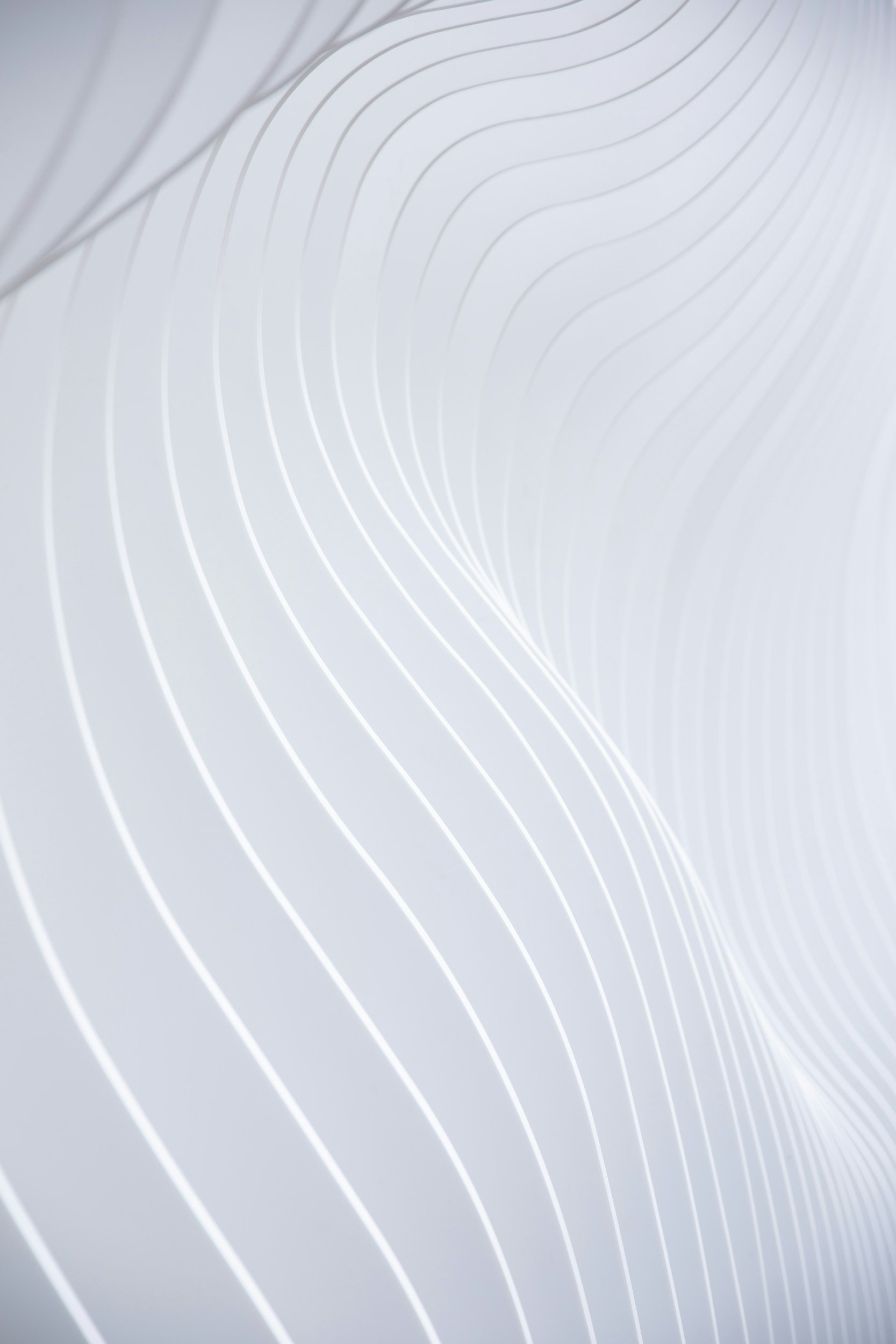 Close-up of a white surface with light gray curved lines.