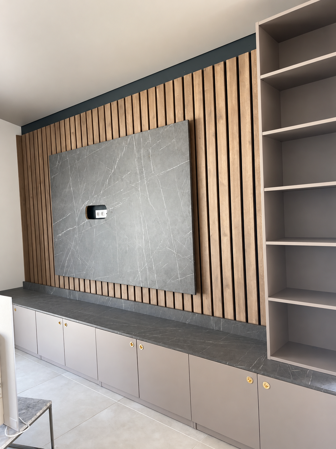 Création d’un meuble TV sur mesure avec parement mural, claustra bois et rangements intégrés.
