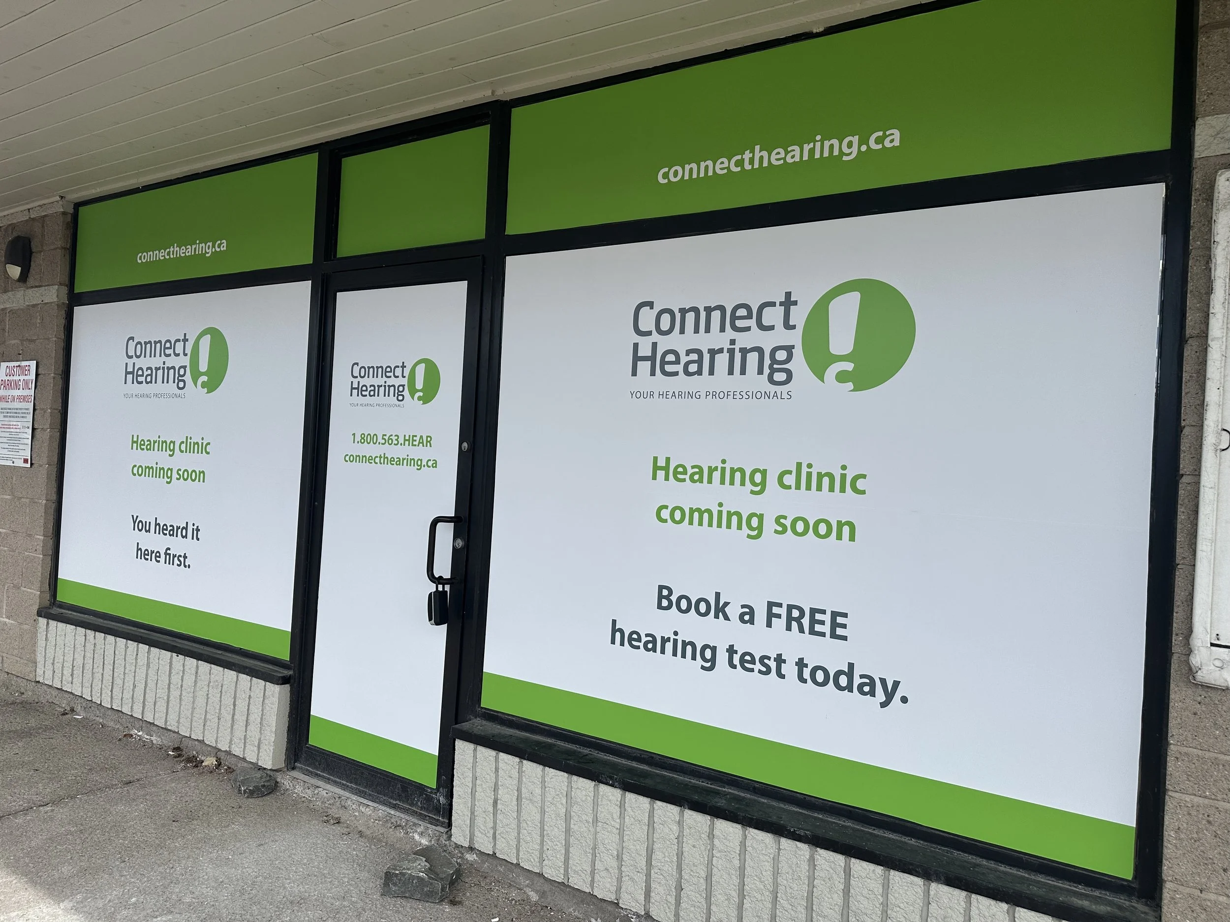Storefront window with advertisements for a hearing clinic, including the website connecthearing.ca, and information about hearing tests and a free consultation.