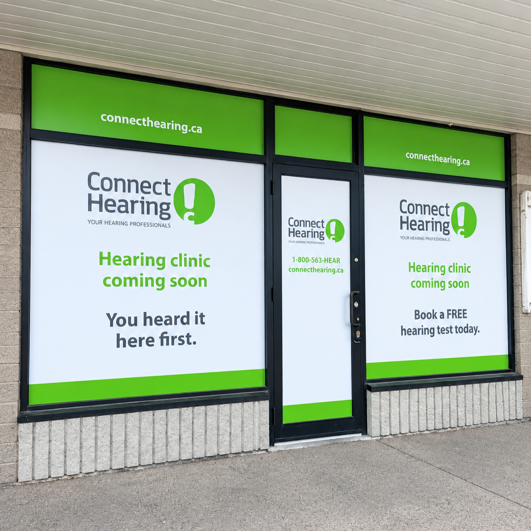 Storefront window advertising Connect Hearing with signs mentioning a coming hearing clinic, free hearing test, and website connecthearing.ca.