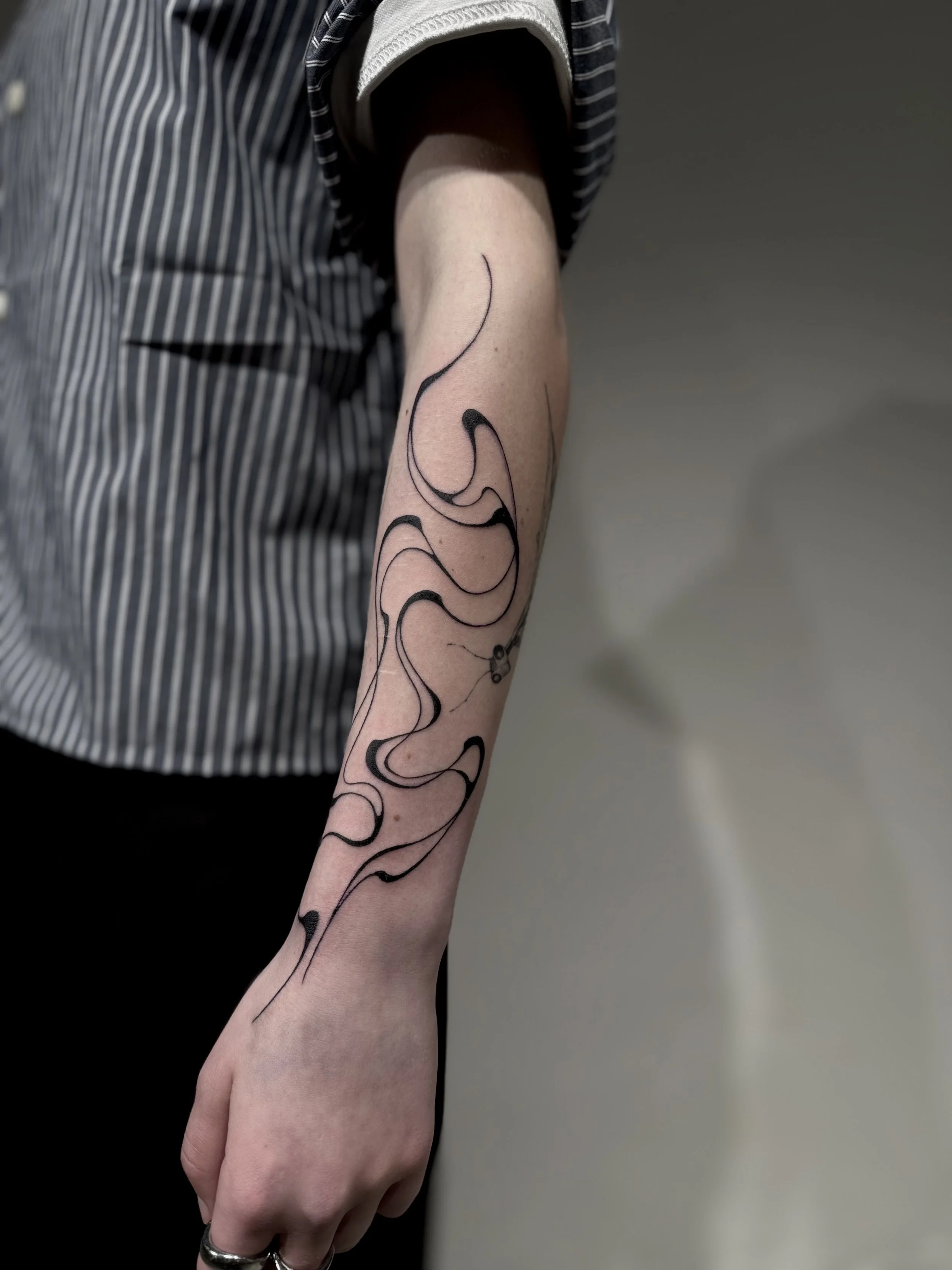 Armtattoo mit abstrakten schwarzen Flowy Linien
