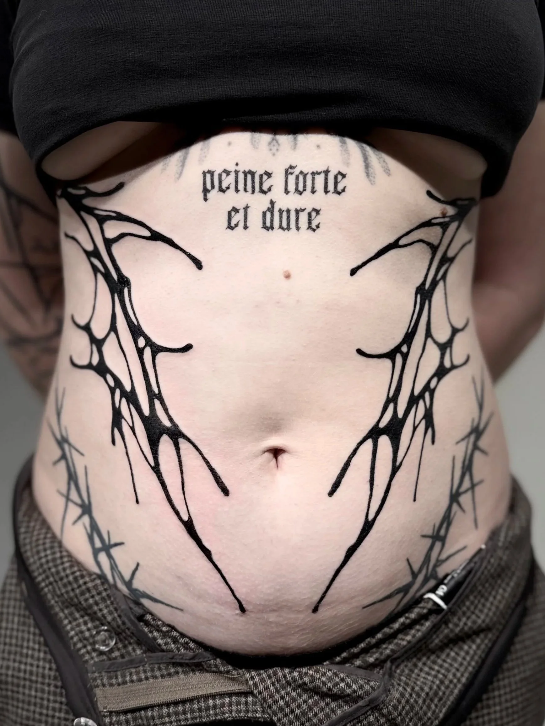 Abstraktes Symmetrisches Bauchtattoo mit Tintenartiger Struktur