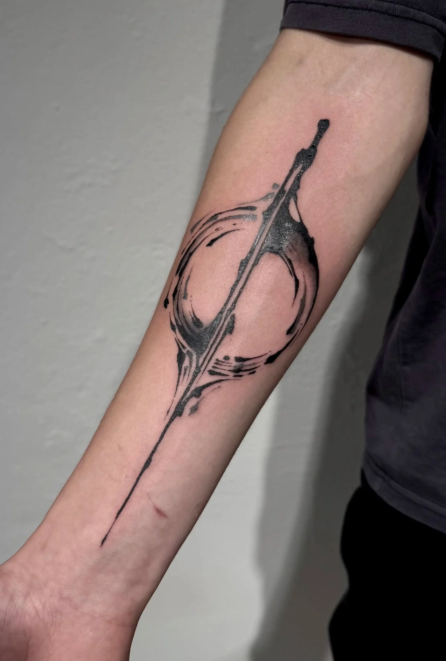 Abstraktes Schwarzes Loch Tattoo auf Unterarm