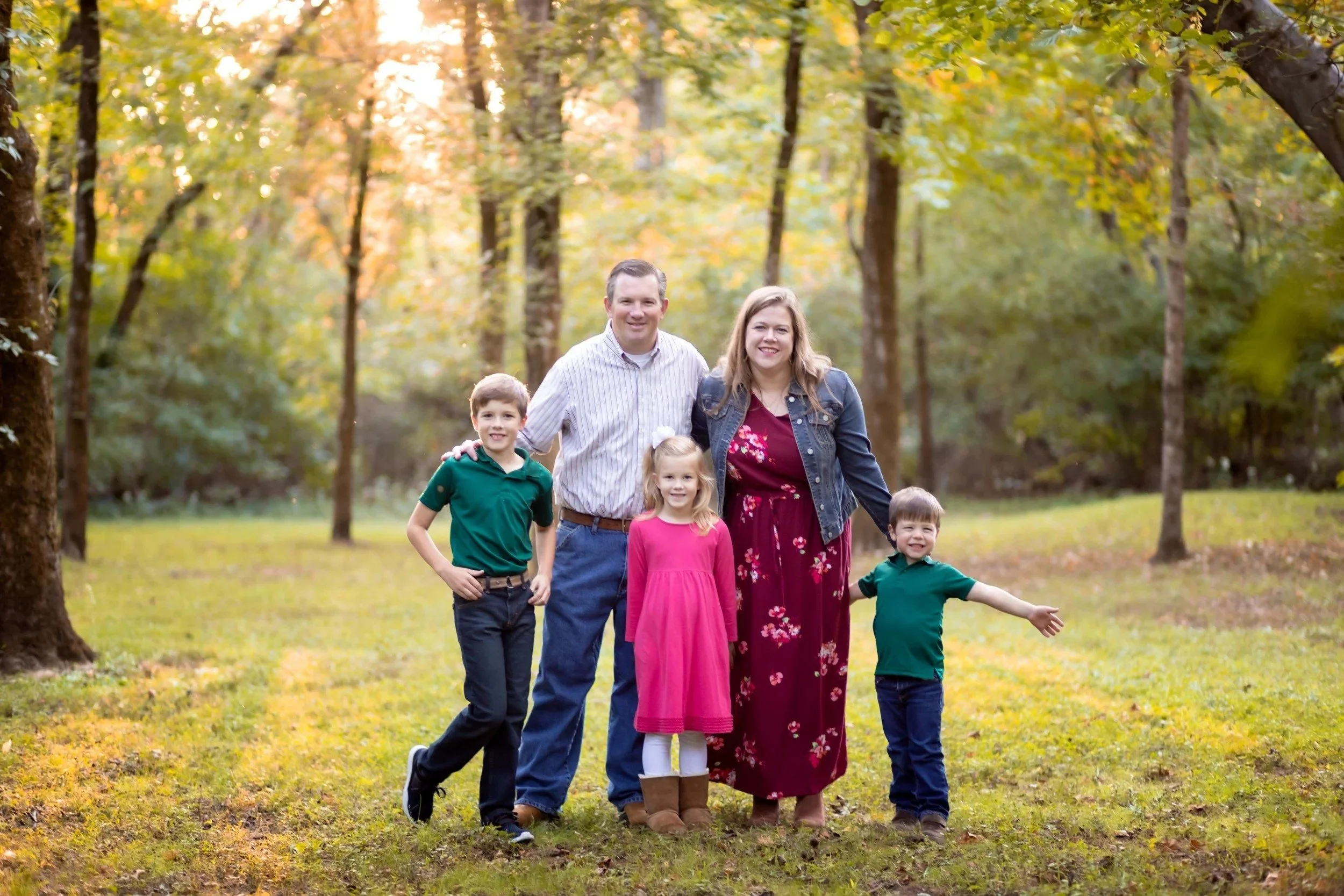 Family of five in a sunny grassy field at Aspen Grove Park in Franklin, TN