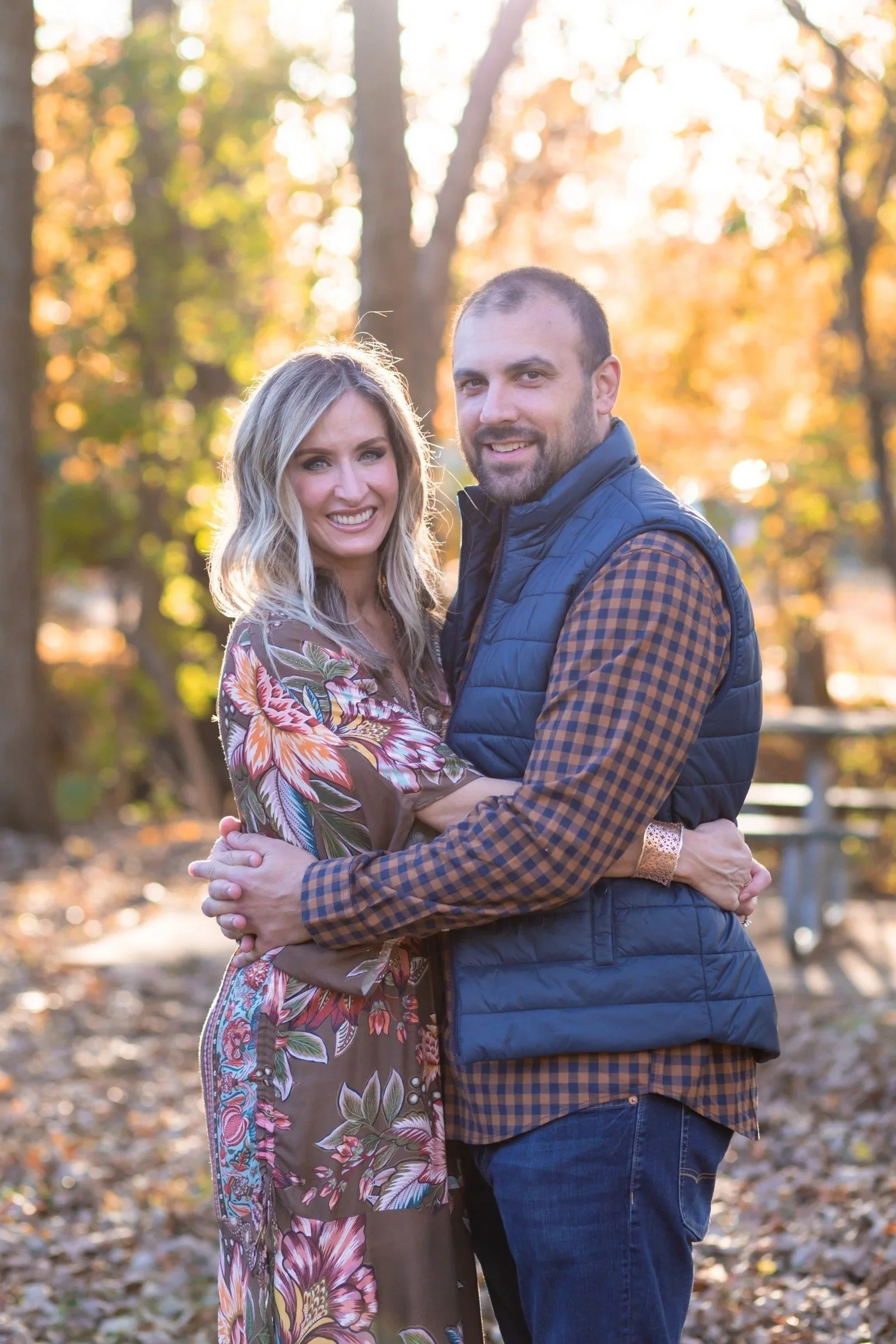 Couple embracing and smiling among fall trees