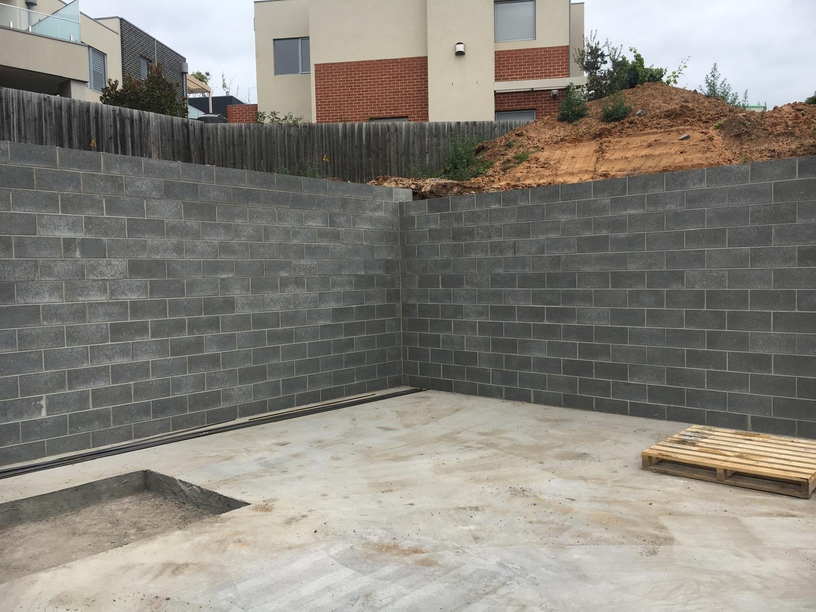 Grey block retaining walls built around a new patio area.