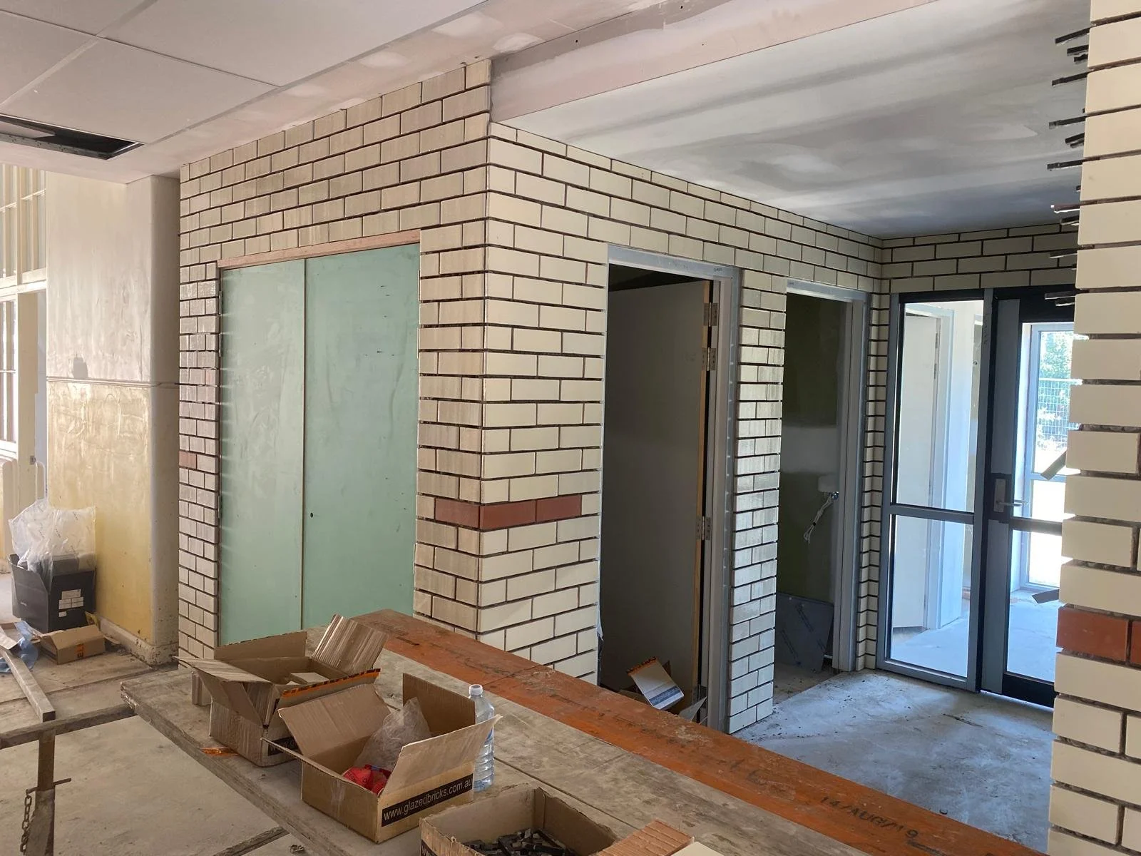 Neat cream brickwork laid around an interior doorway, mid-build.