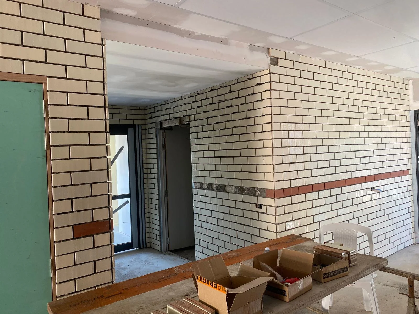 Cream interior brick walls finished with a contrasting red-brick feature course.