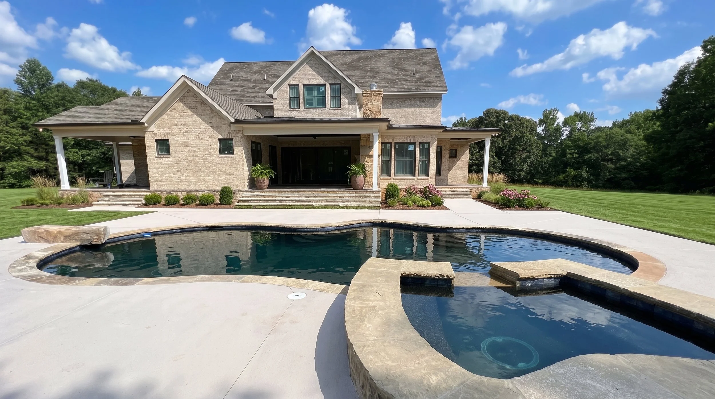 A modern two-story house with a backyard pool and landscaped garden under a blue sky with scattered clouds.