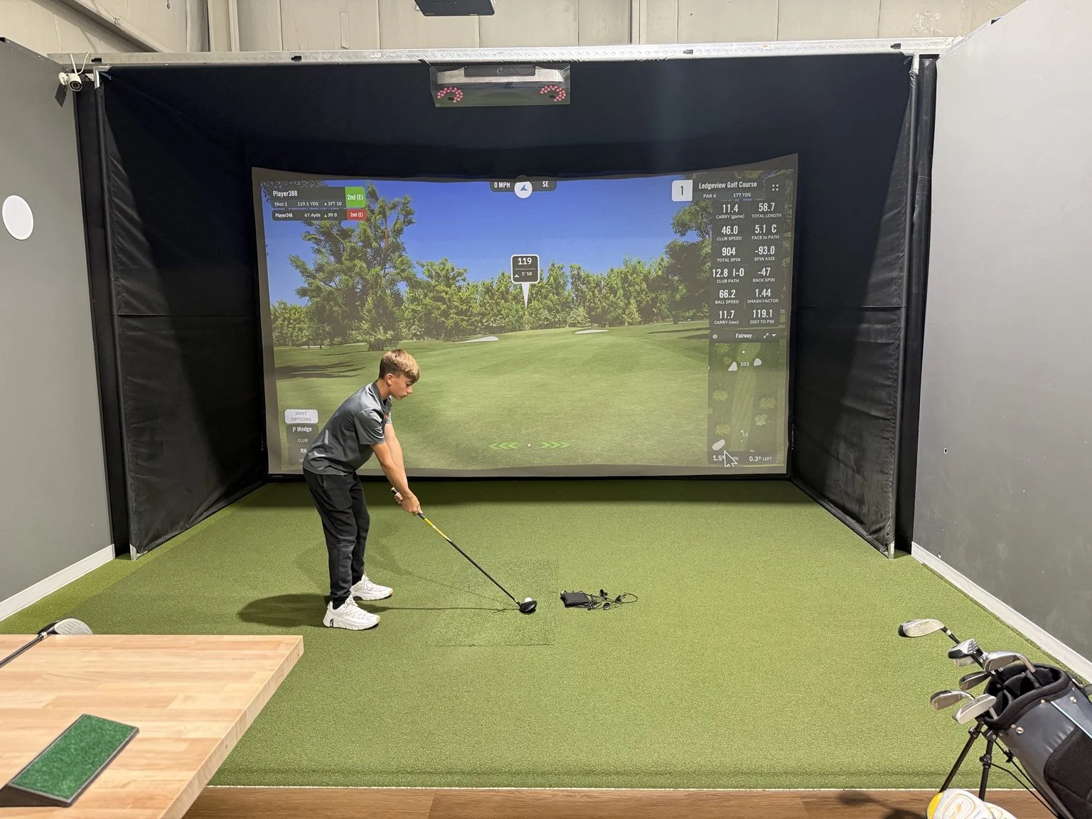 Junior golfer practicing in an Elevate Golf simulator bay