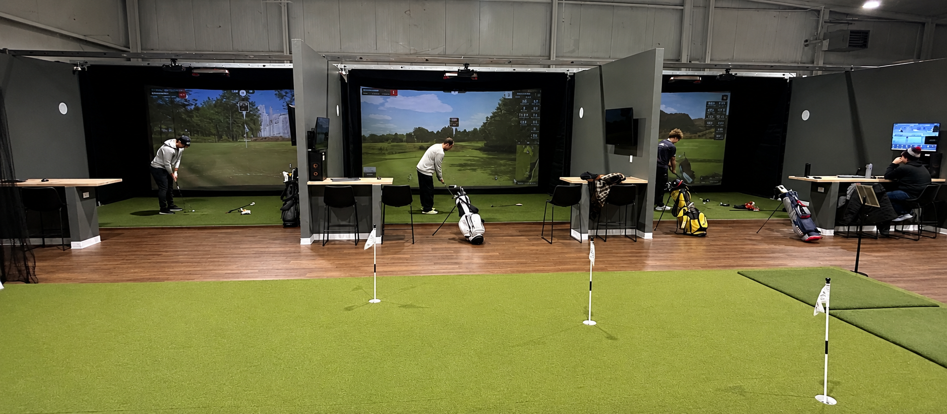 Golfers practice in Elevate Golf’s three-bay indoor simulator facility in Green Bay.