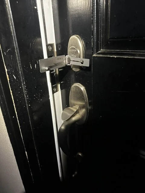 Door with a standard door handle and a latch lock engaged with a wedge block.