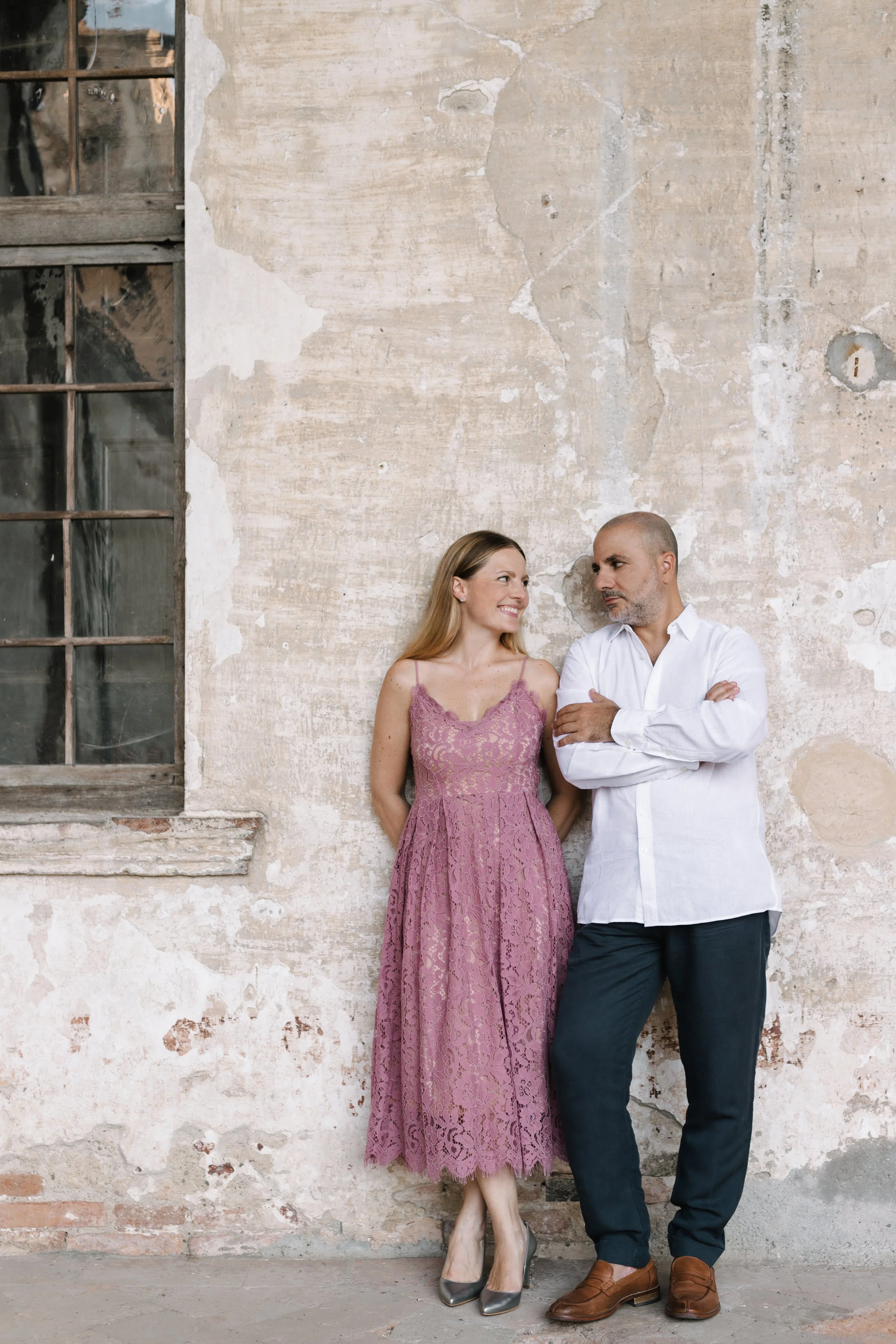 Pianists Sara Costa and Fabiano Casanova of Costa & Casanova Piano Duo standing against a stone wall.