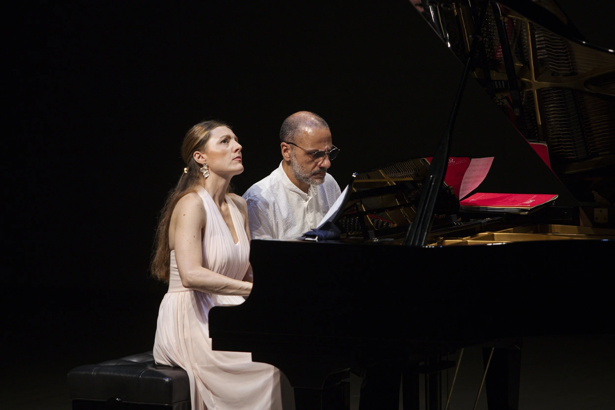 Sara Costa and Fabiano Casanova performing together at a grand piano during a concert.