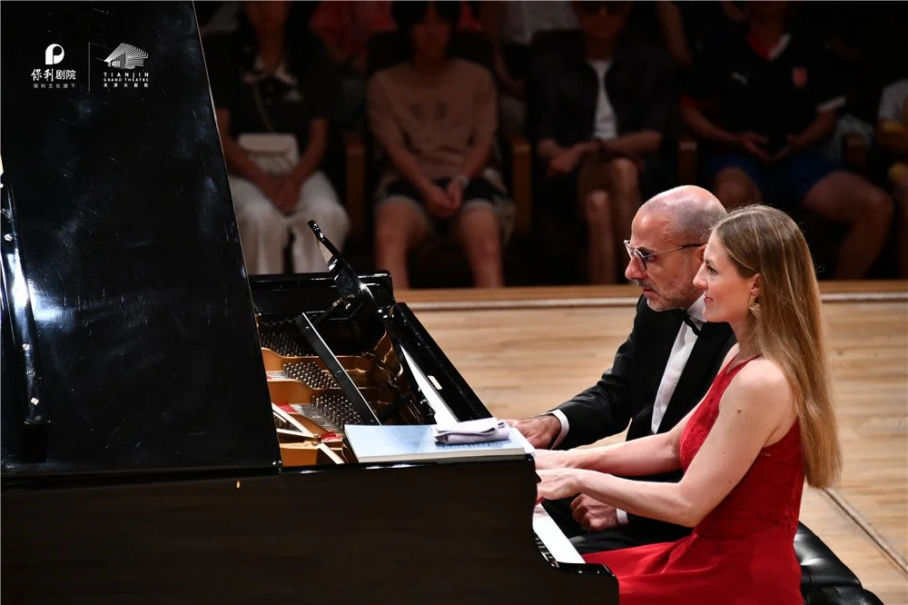 Sara Costa and Fabiano Casanova performing piano four hands on stage.