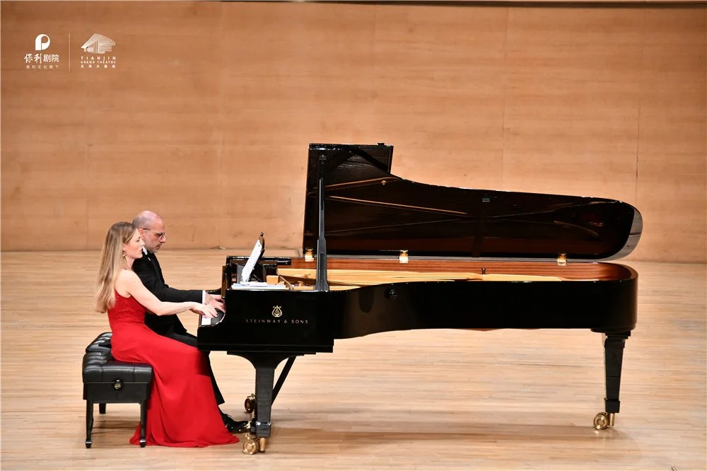 Costa & Casanova Piano Duo performing piano four hands on stage in a theatre