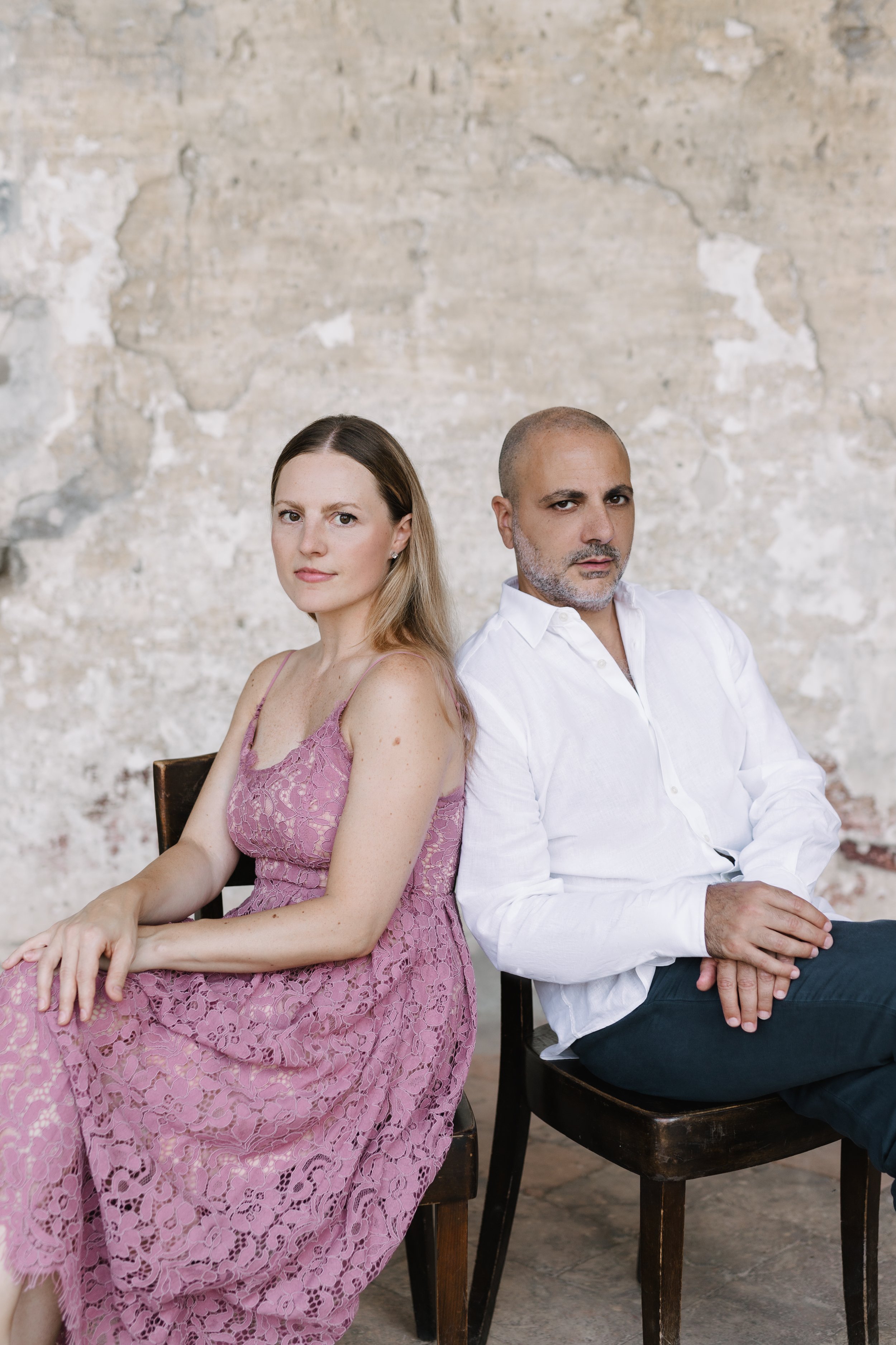     Sara Costa and Fabiano Casanova photographed together against a stone wall.