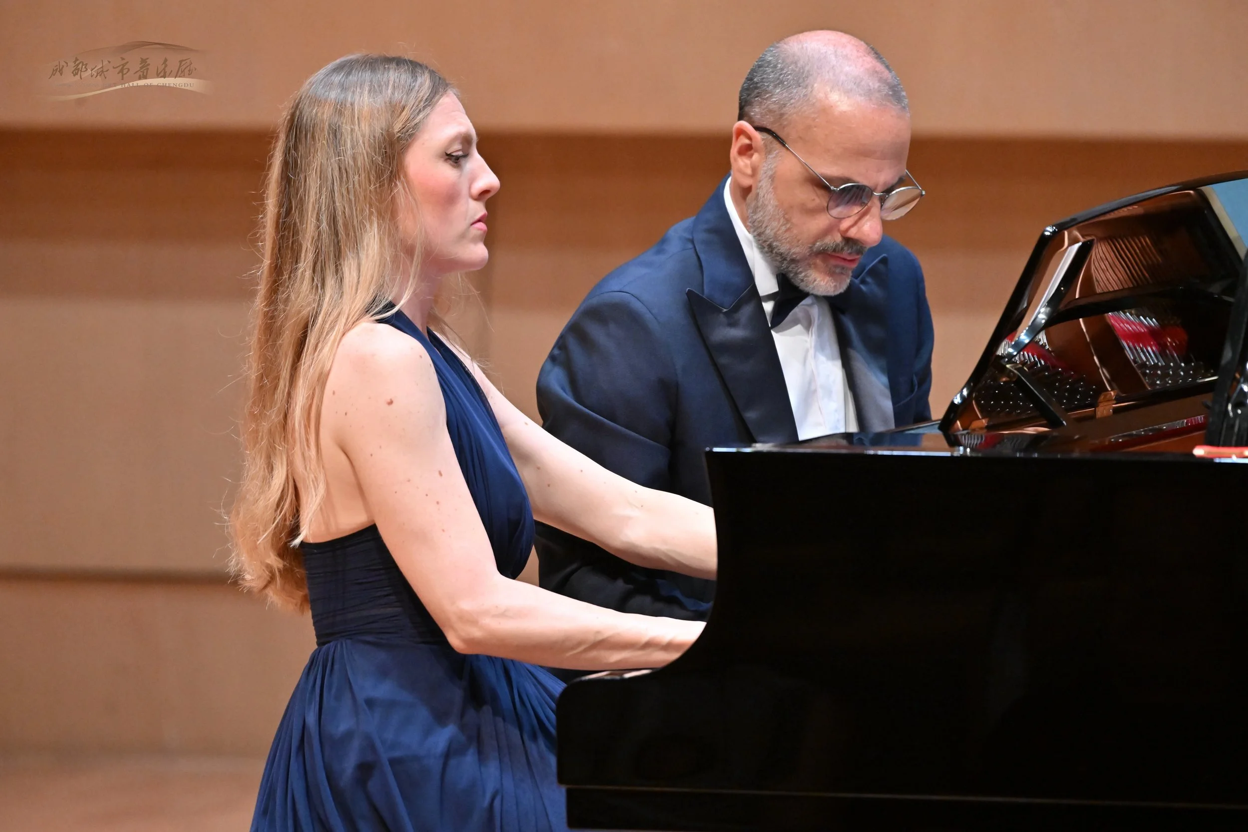 Sara Costa and Fabiano Casanova performing piano four hands during a live concert.