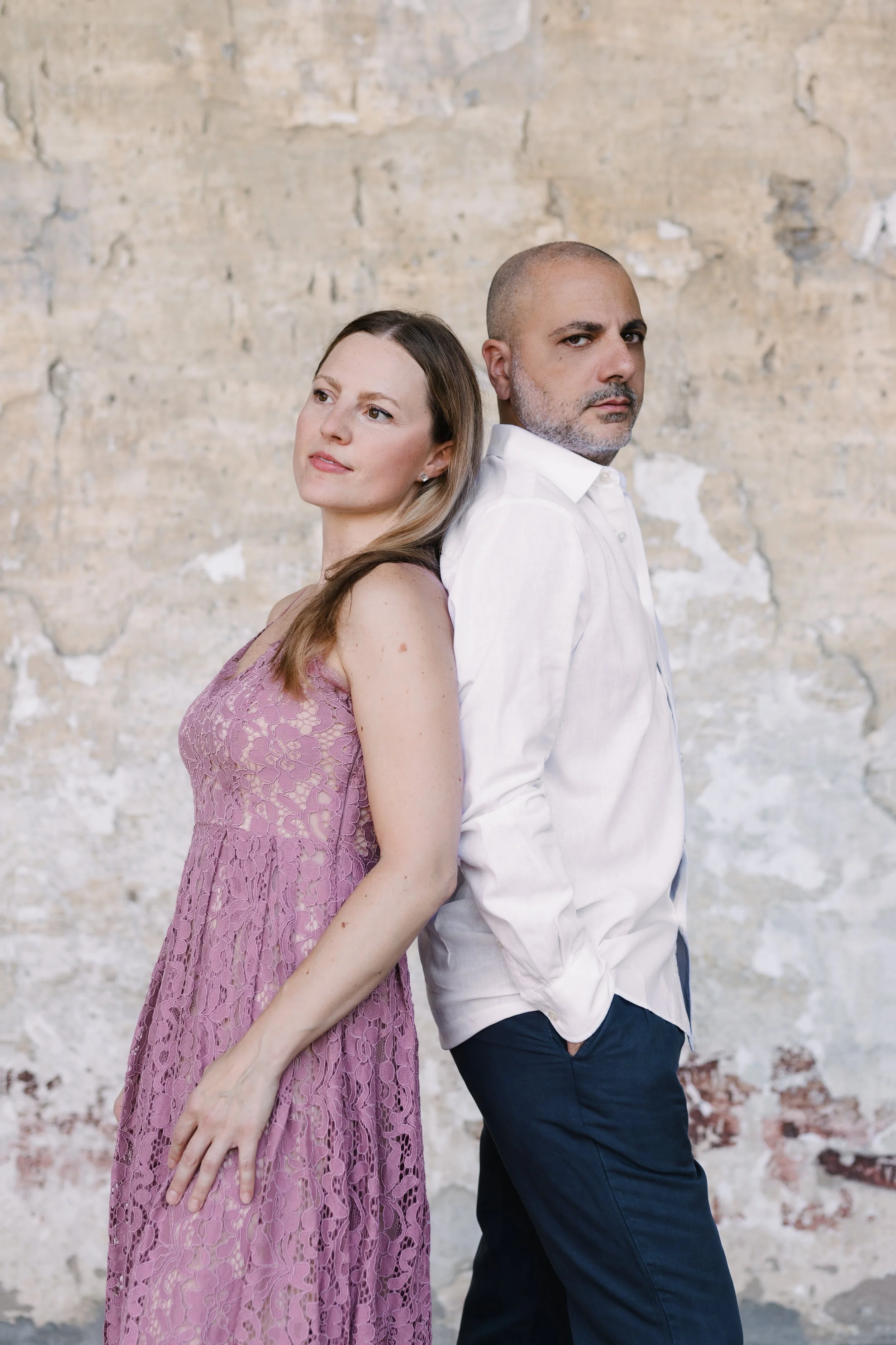     Sara Costa and Fabiano Casanova photographed together against a stone wall.