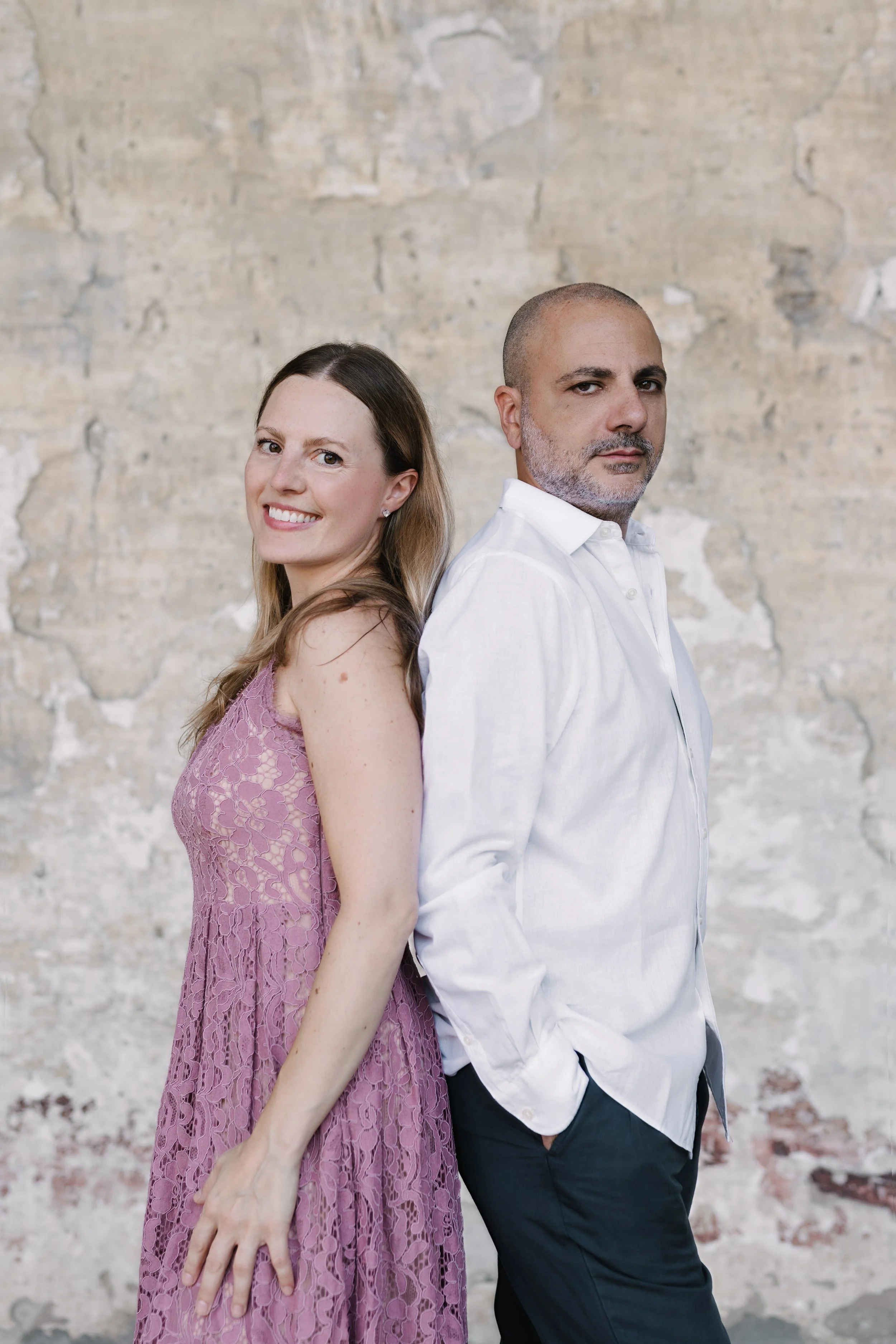 Sara Costa and Fabiano Casanova, Costa & Casanova Piano Duo, photographed together against a stone wall.