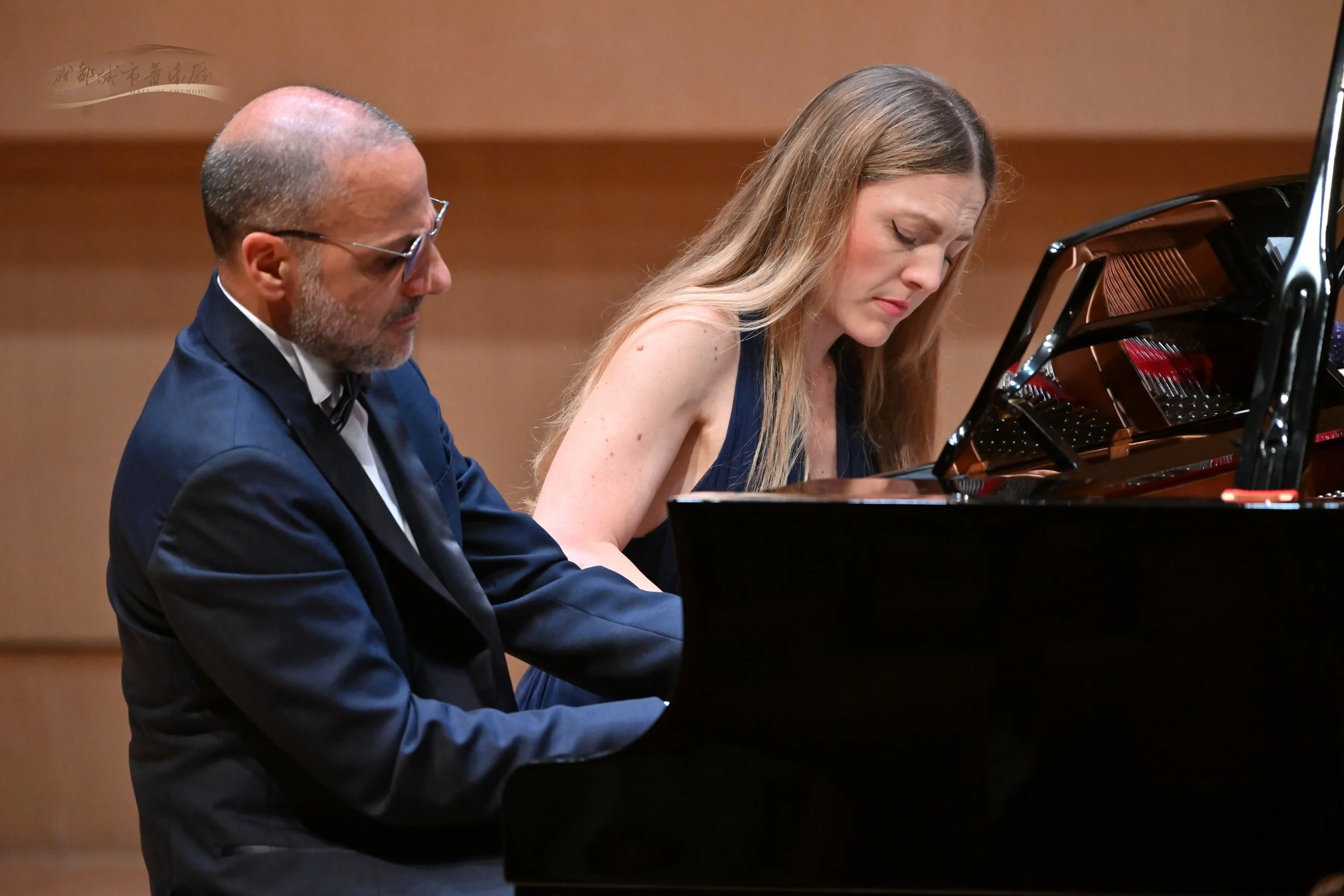 Costa & Casanova Piano Duo performing together at the piano during a live concert.