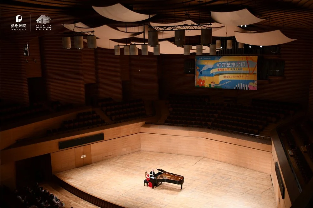 Costa & Casanova Piano Duo performing on stage in a concert hall.