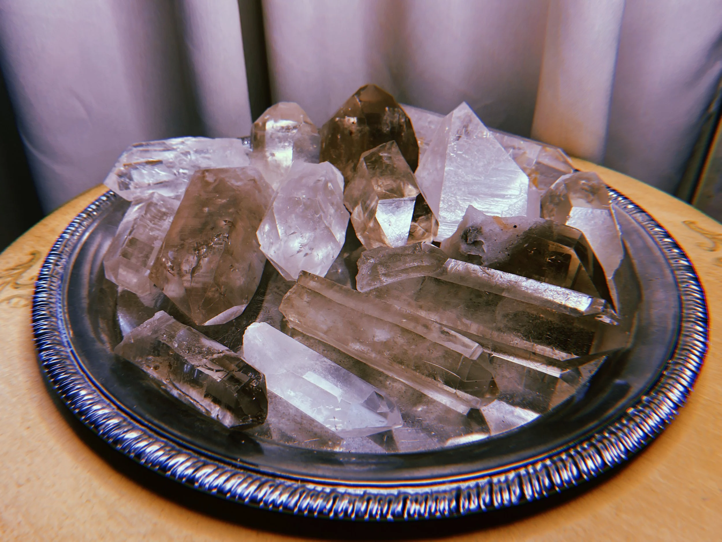 A tray filled with clear and dark brown rocks on a decorative plate with a yellow border.