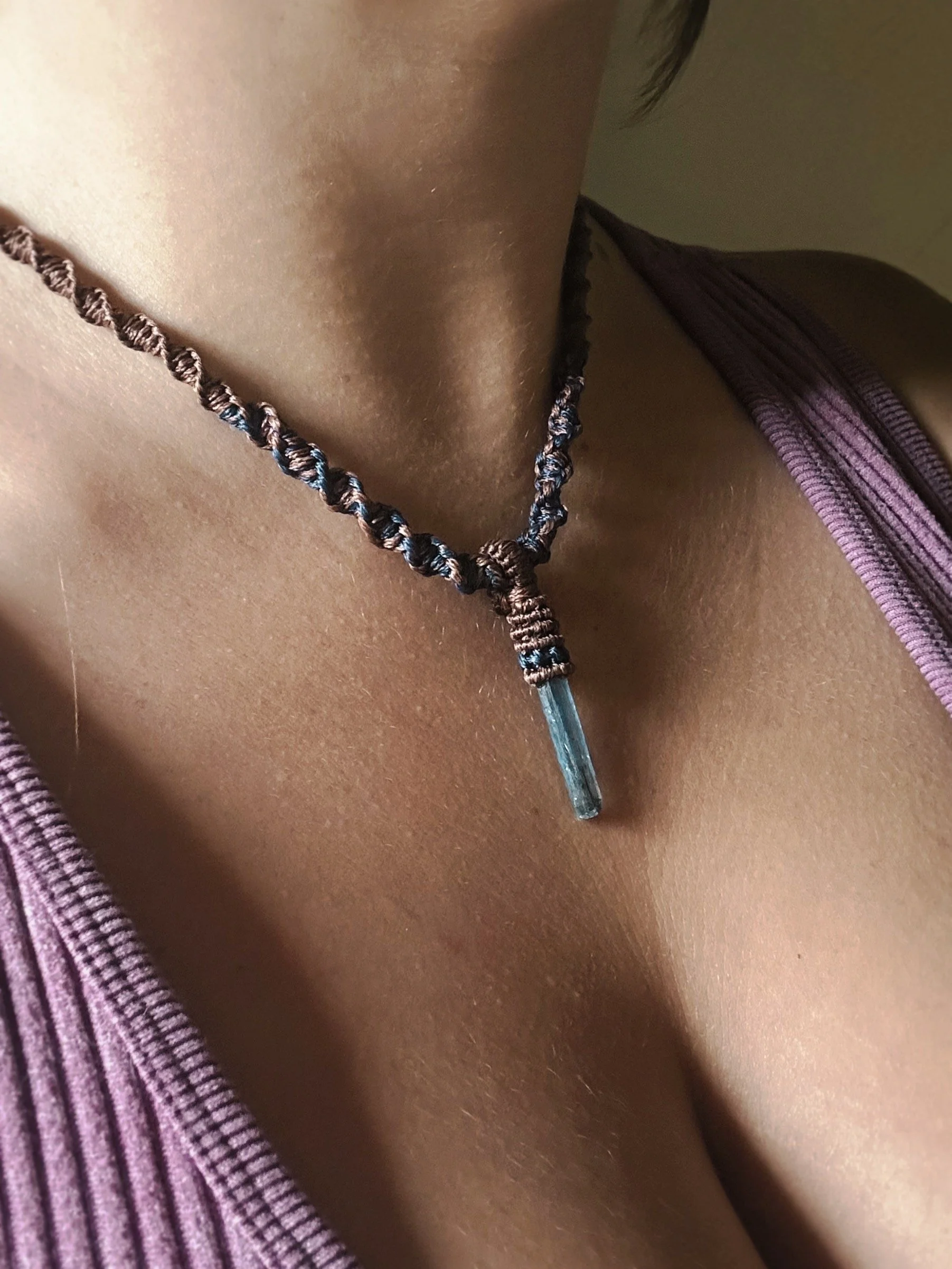 Close-up of a person's chest with a medical tube inserted, wearing a purple striped garment.
