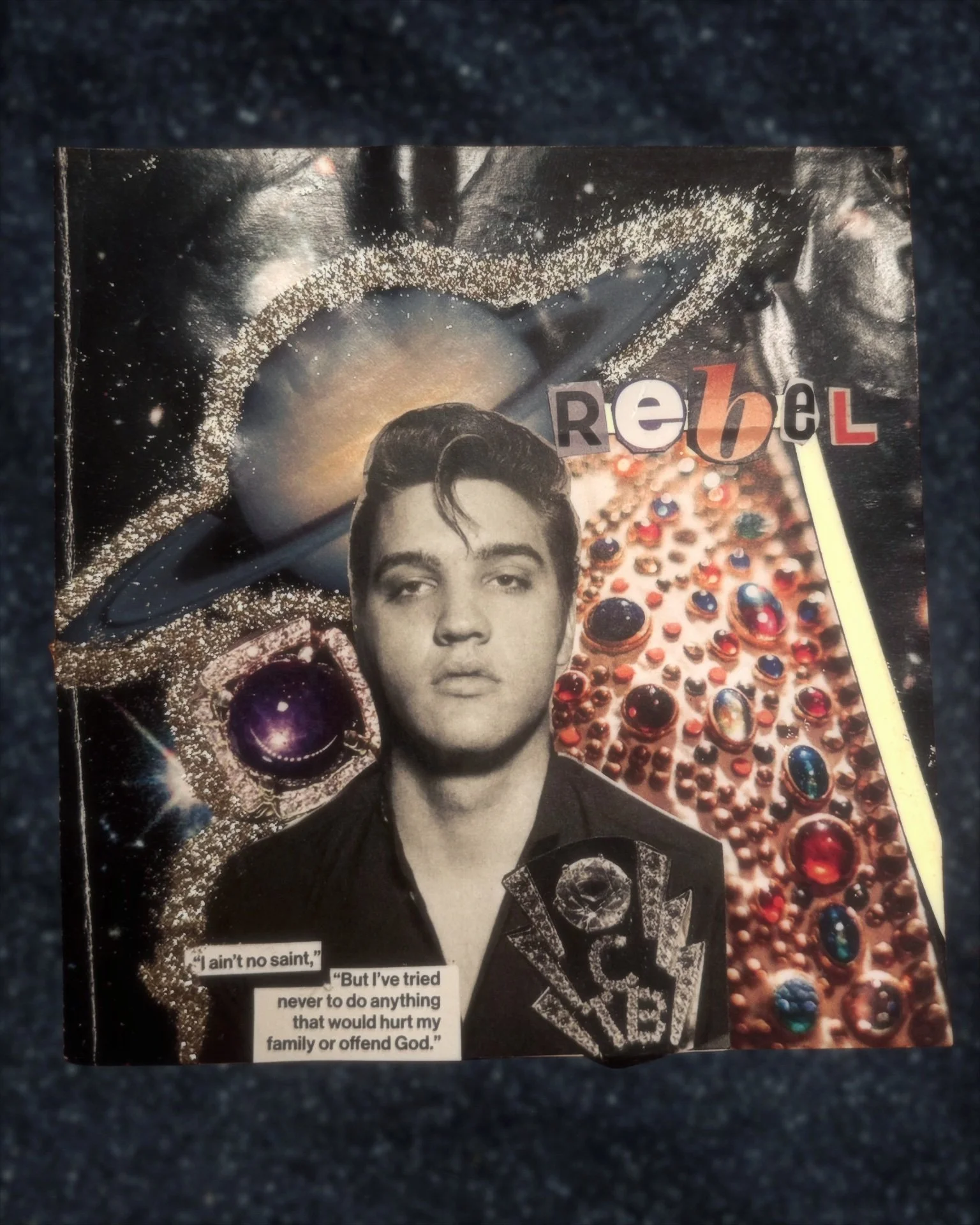 Black and white photo of Elvis Presley with a colorful background of jewelry and space-themed elements, including planets and stars. The word 'Rebel' is spelled out with cut-out letters. A quote from Elvis is partially visible at the bottom.