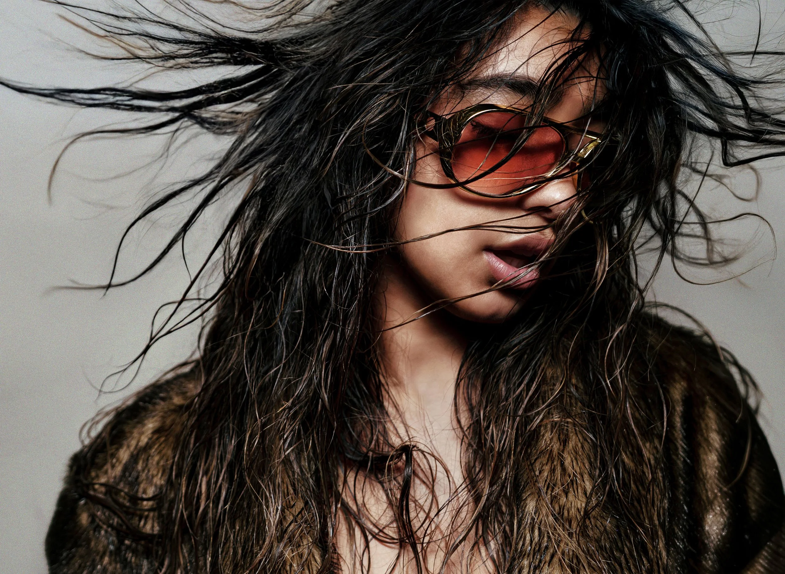 Close-up fashion portrait wearing red sunglasses with windblown hair. CINDY LAUREN GULLO
