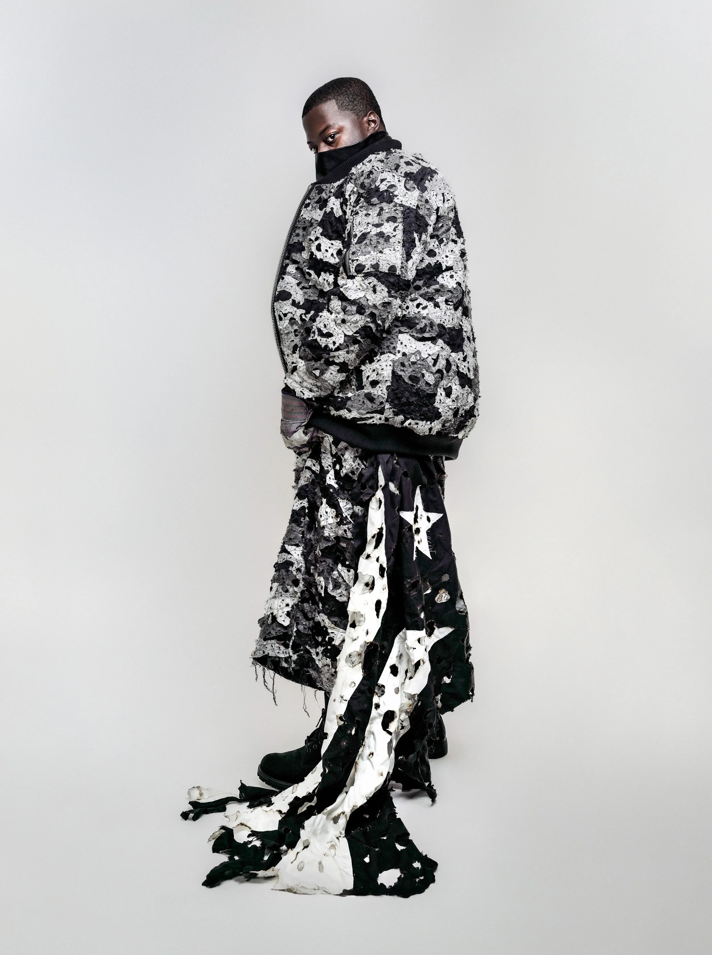 Editorial fashion portrait in a patterned outfit against a white background. DIEHANESLITO