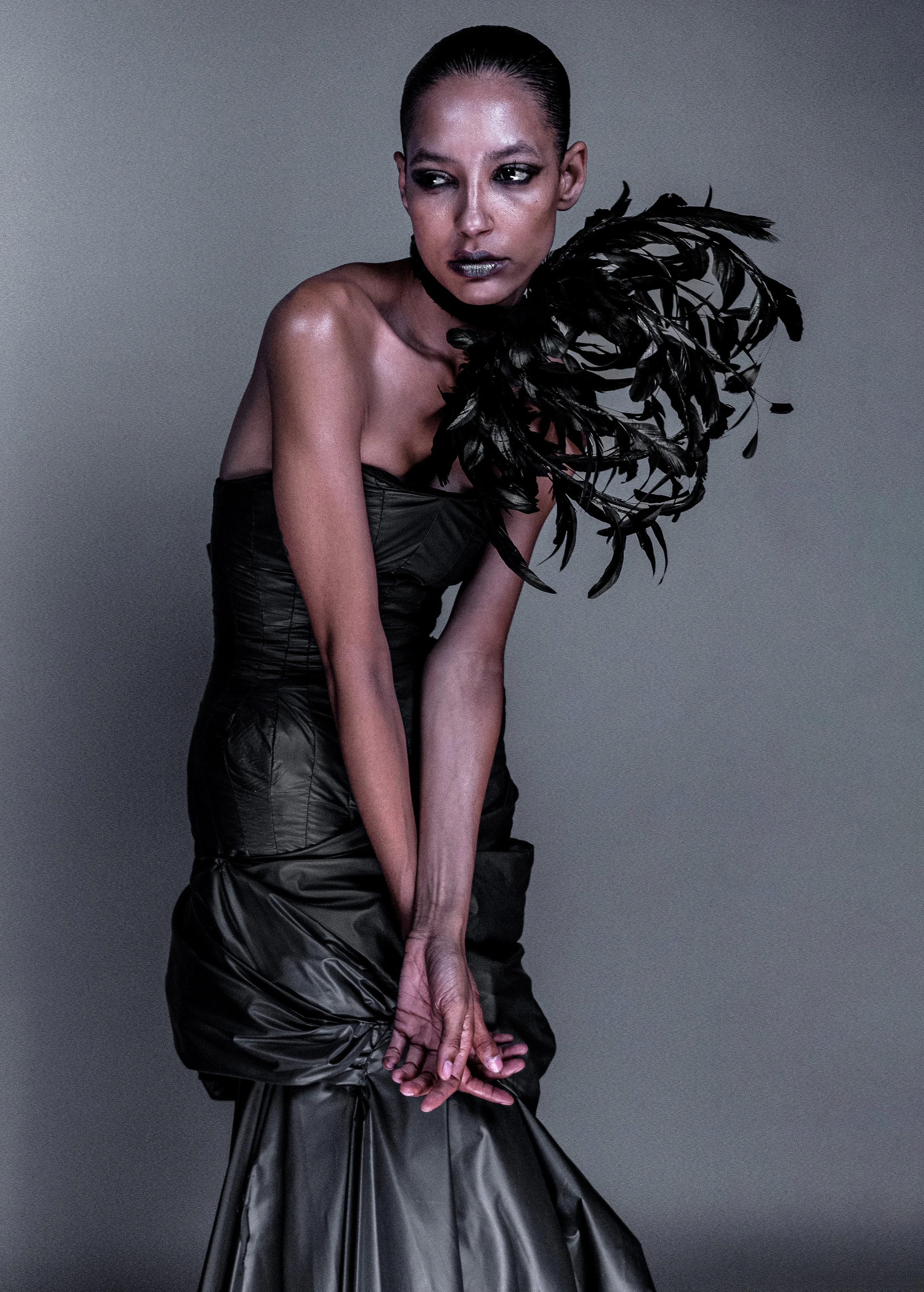 Studio fashion portrait of a woman in a black feathered outfit. MARIAJOSE MARTE