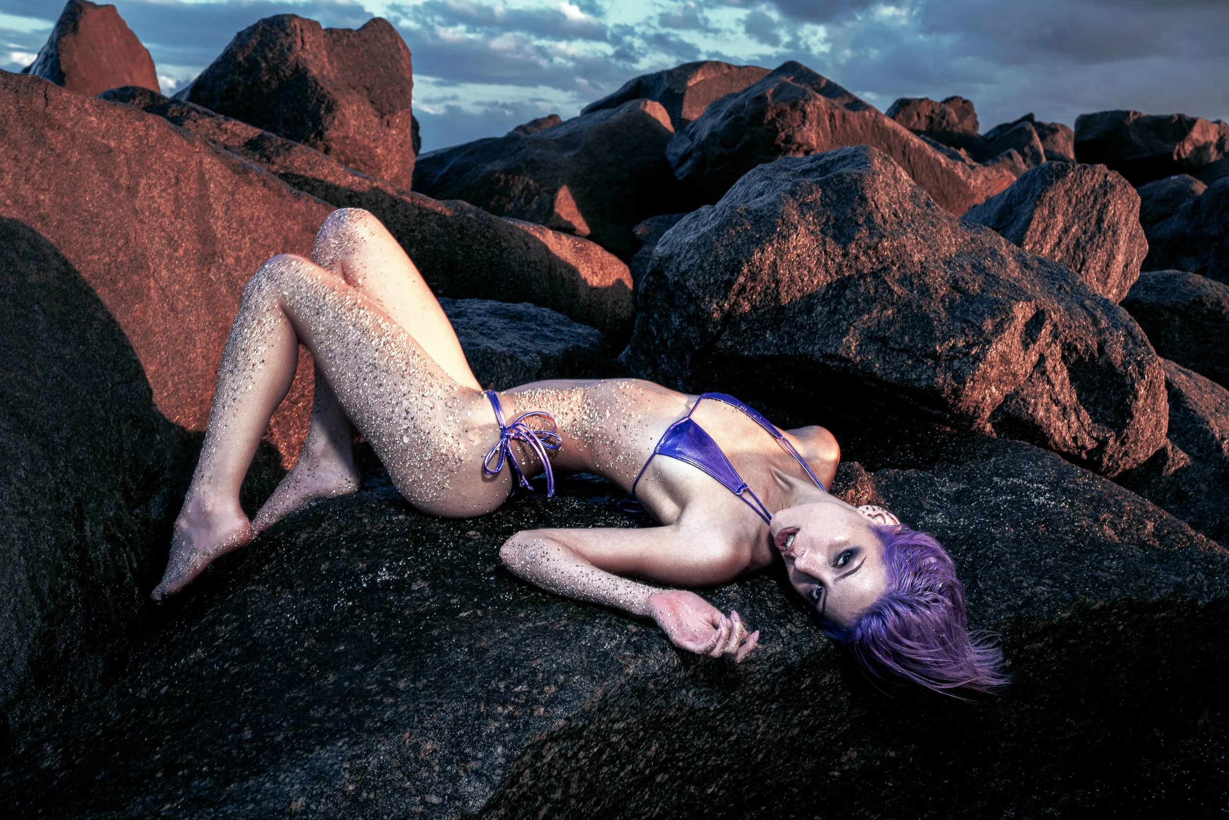 Editorial portrait of a woman lying on rocks outdoors. PARIS OSONA