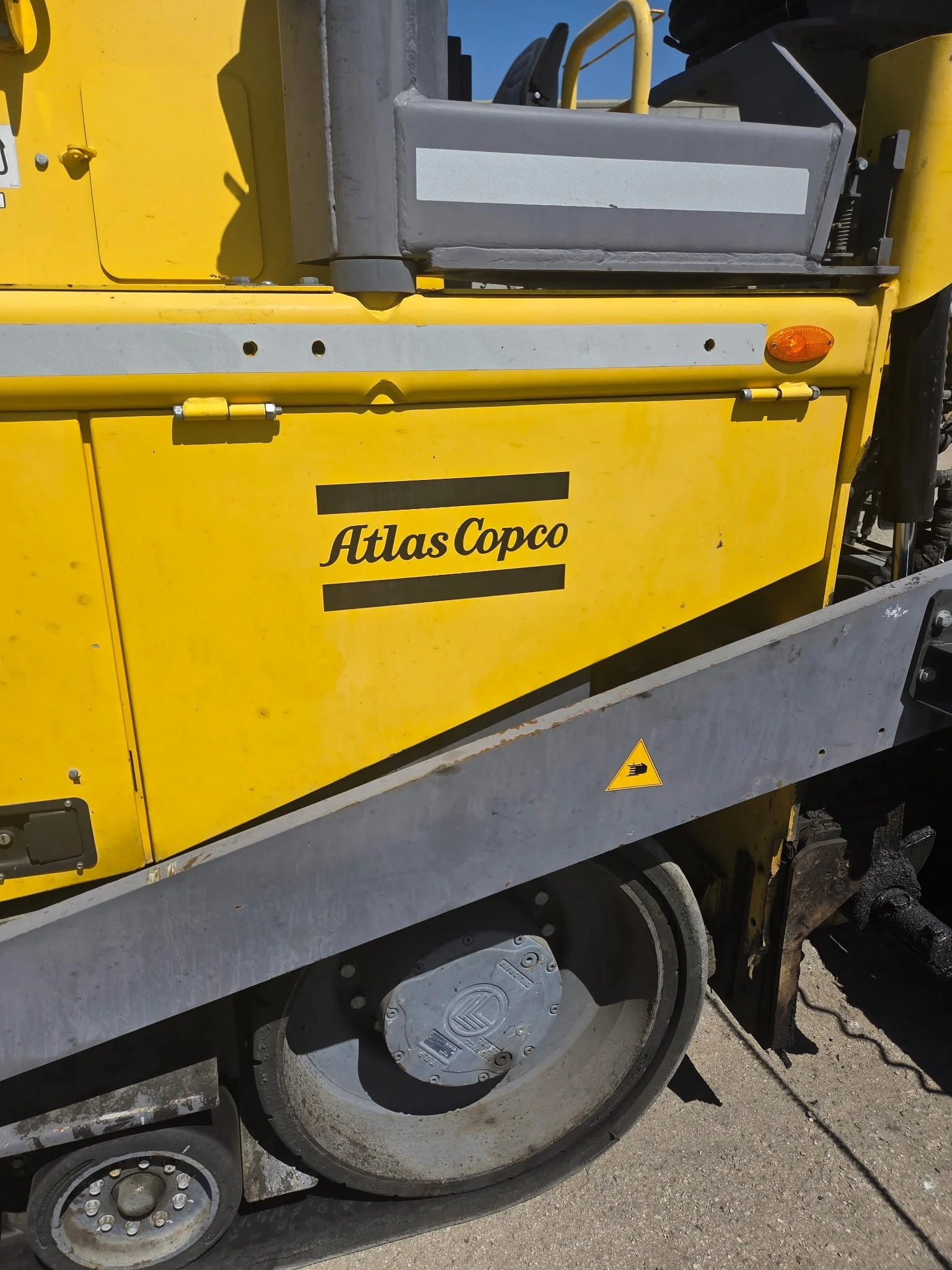 2017 Dynapac F1000T asphalt paver, close-up of yellow side panel with Dynapac branding.